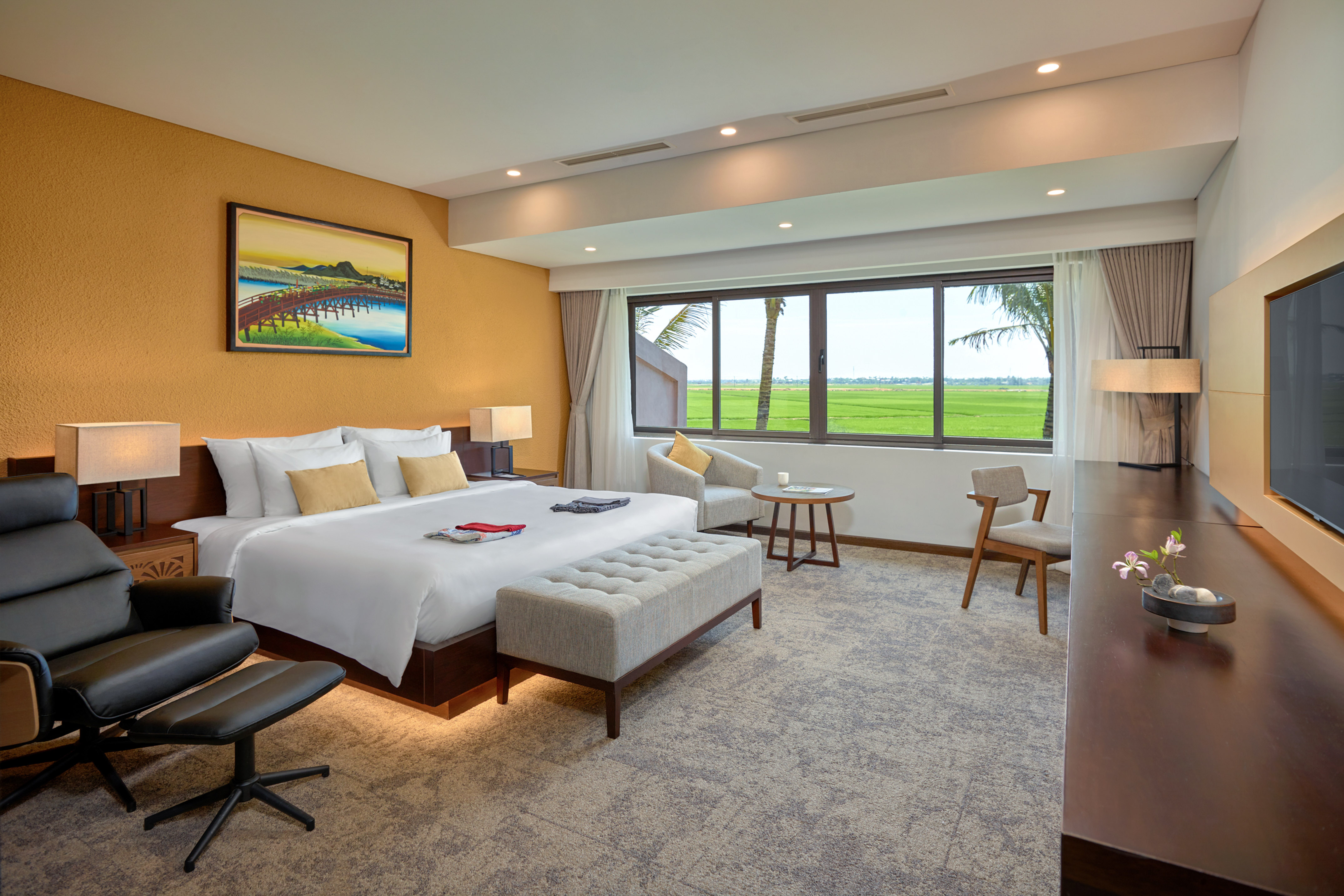 Hotel room with king bed, modern decor, and scenic rice field view.