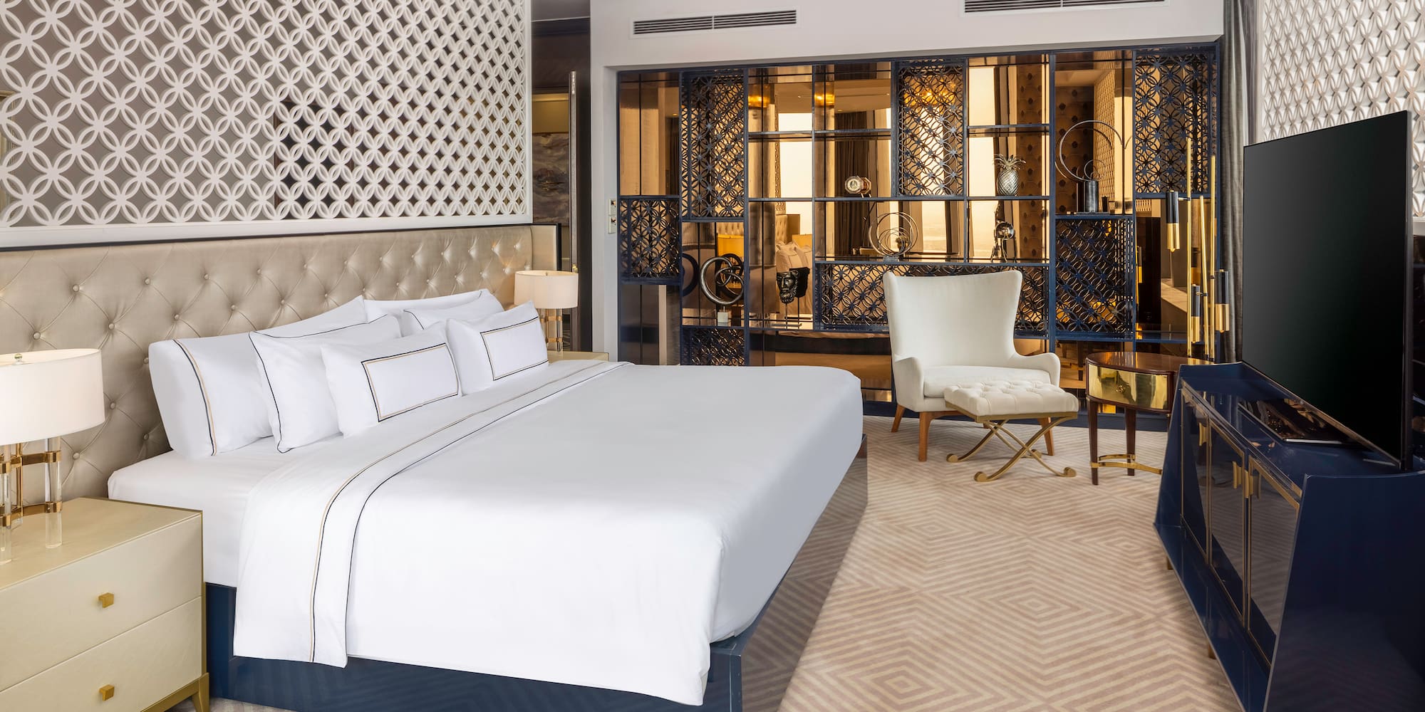 a bedroom with a large bed and a chair