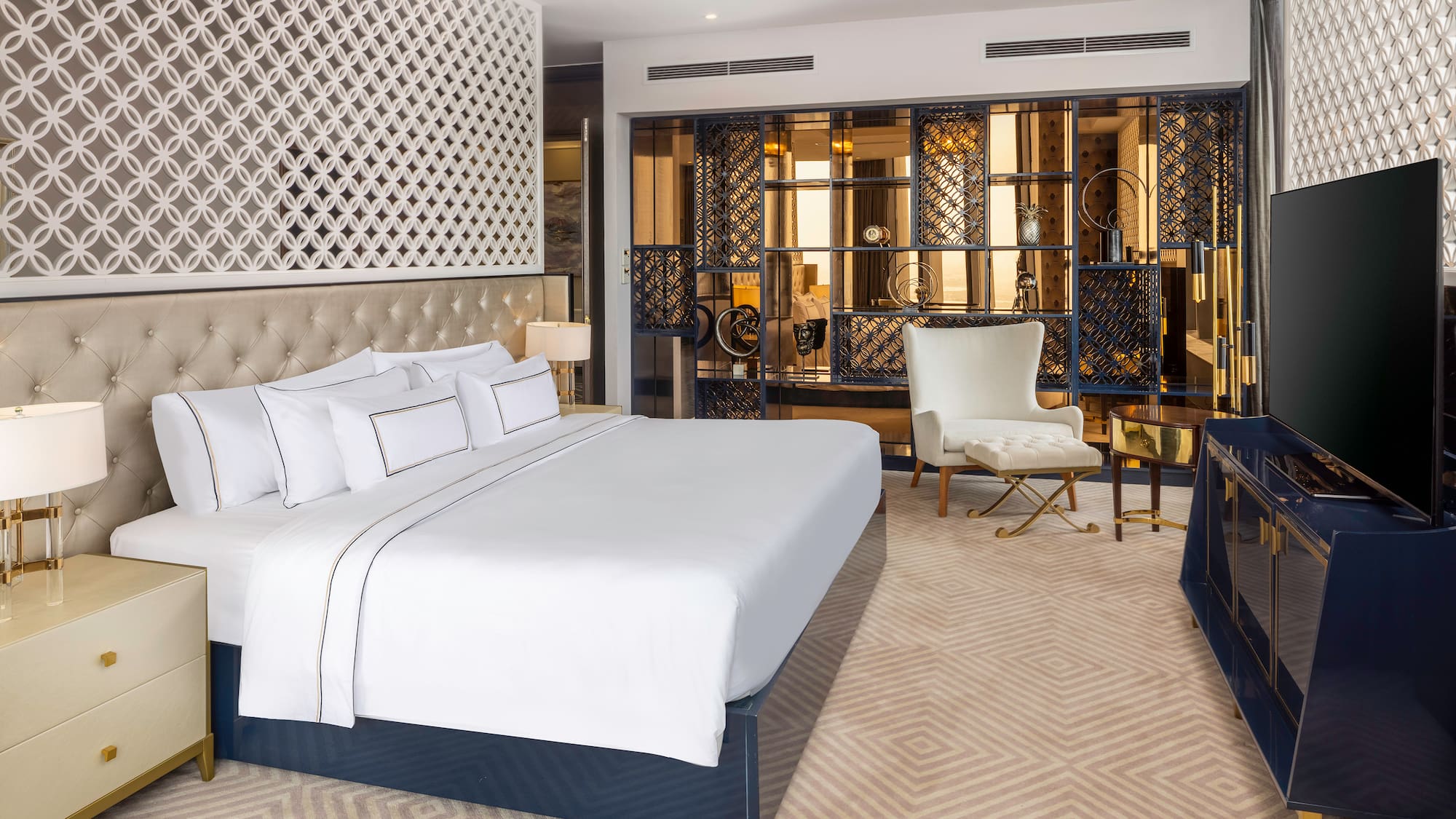 a bedroom with a large bed and a chair