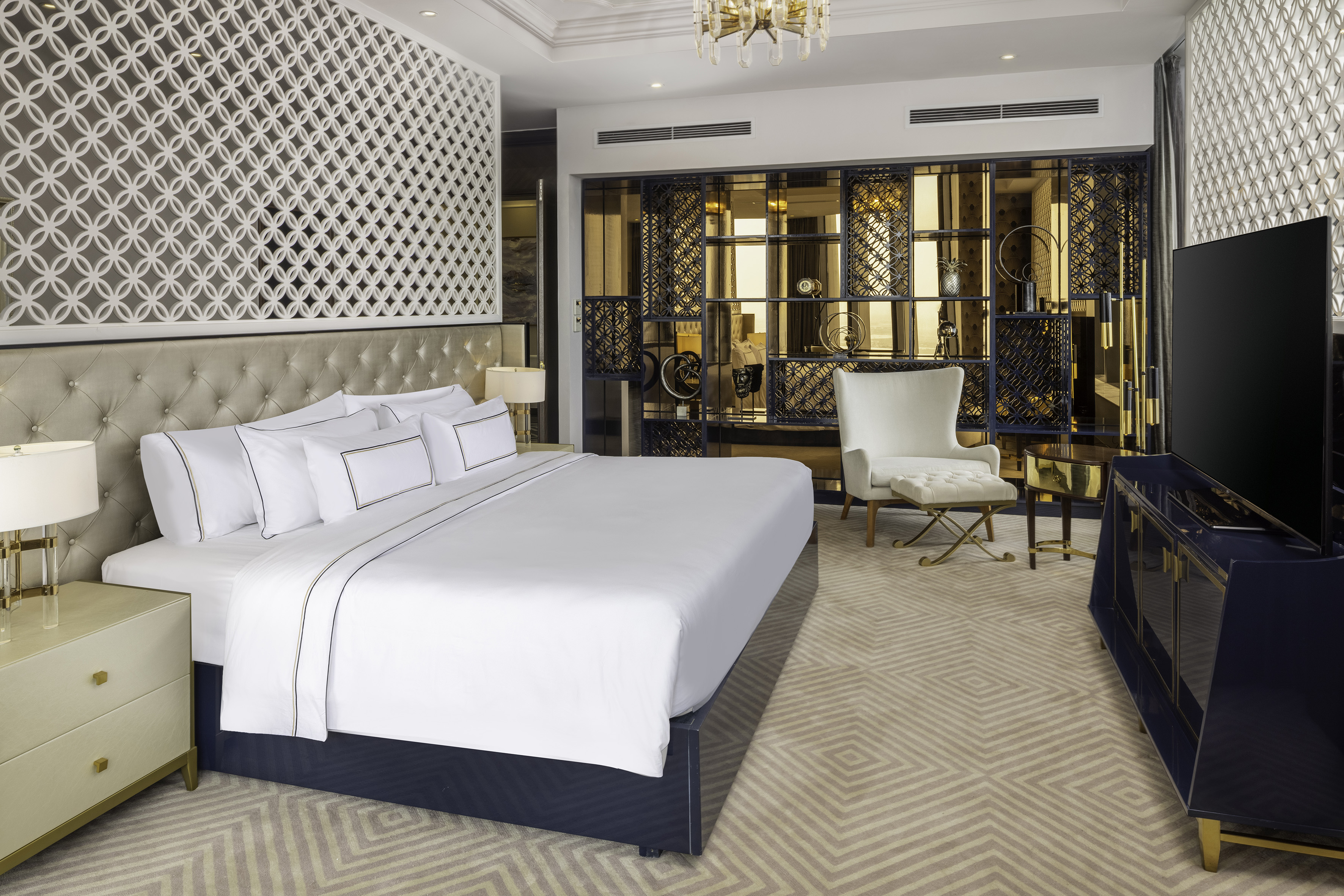 a bedroom with a large bed and a chair