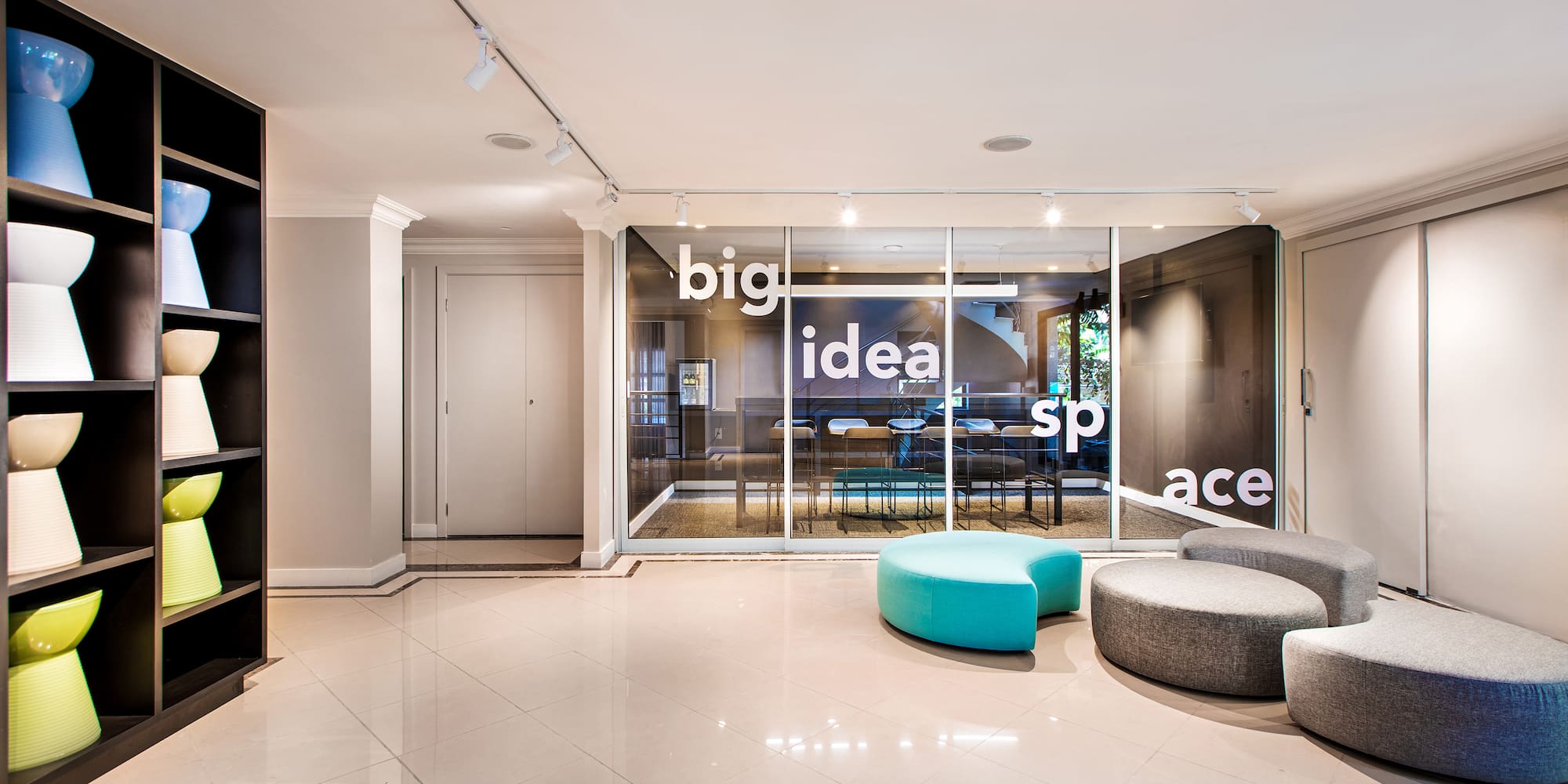 a room with a glass wall and a round blue and grey chair