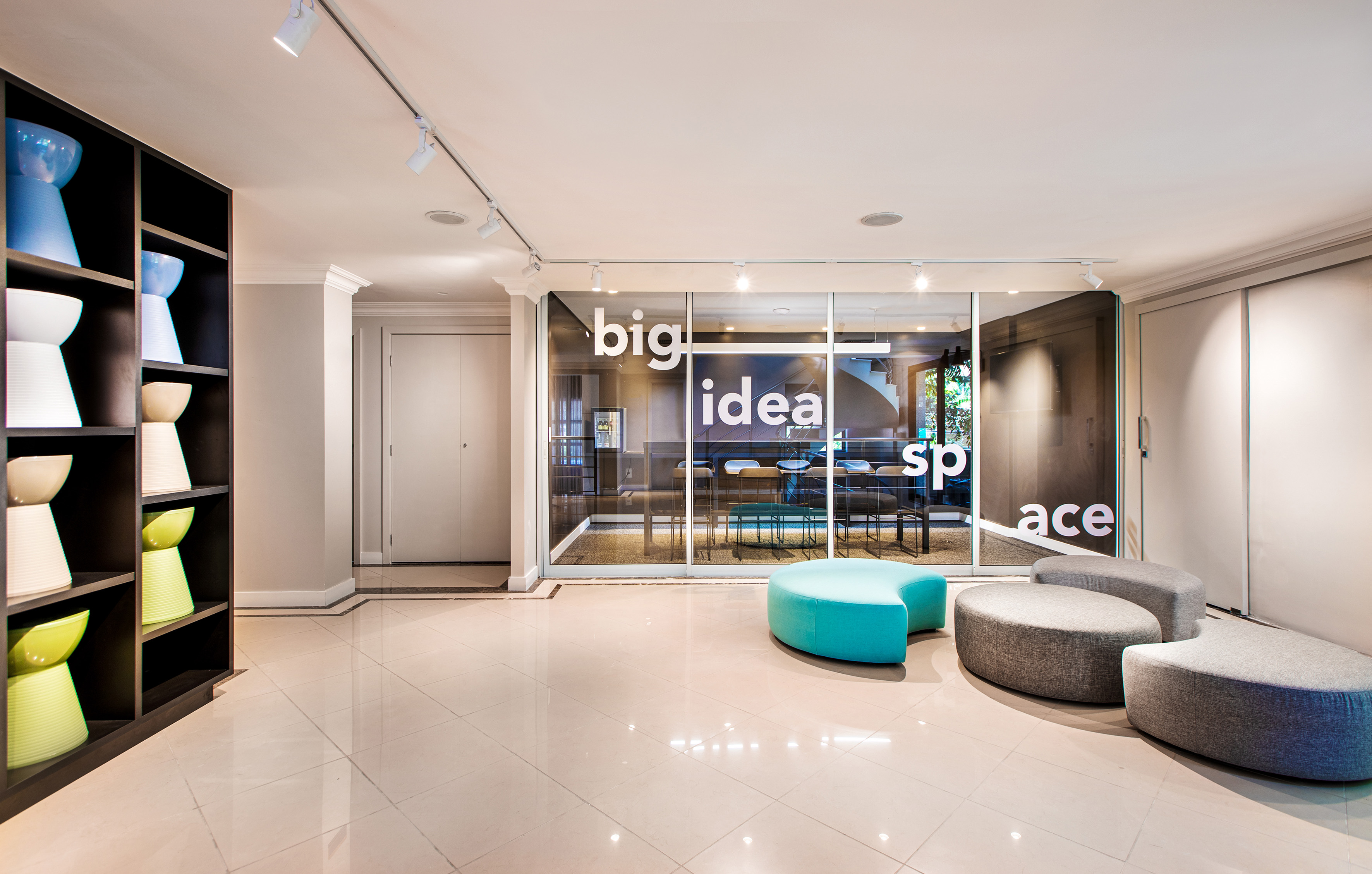 a room with a glass wall and a round blue and grey chair