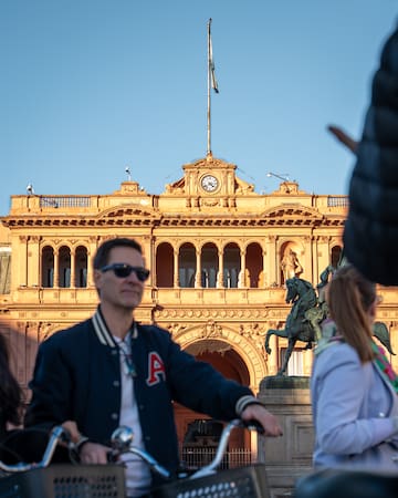 a man riding a bicycle in front of a building
