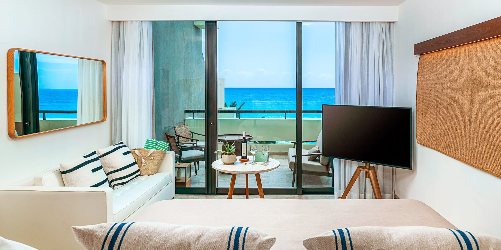 a room with a television and a view of the ocean