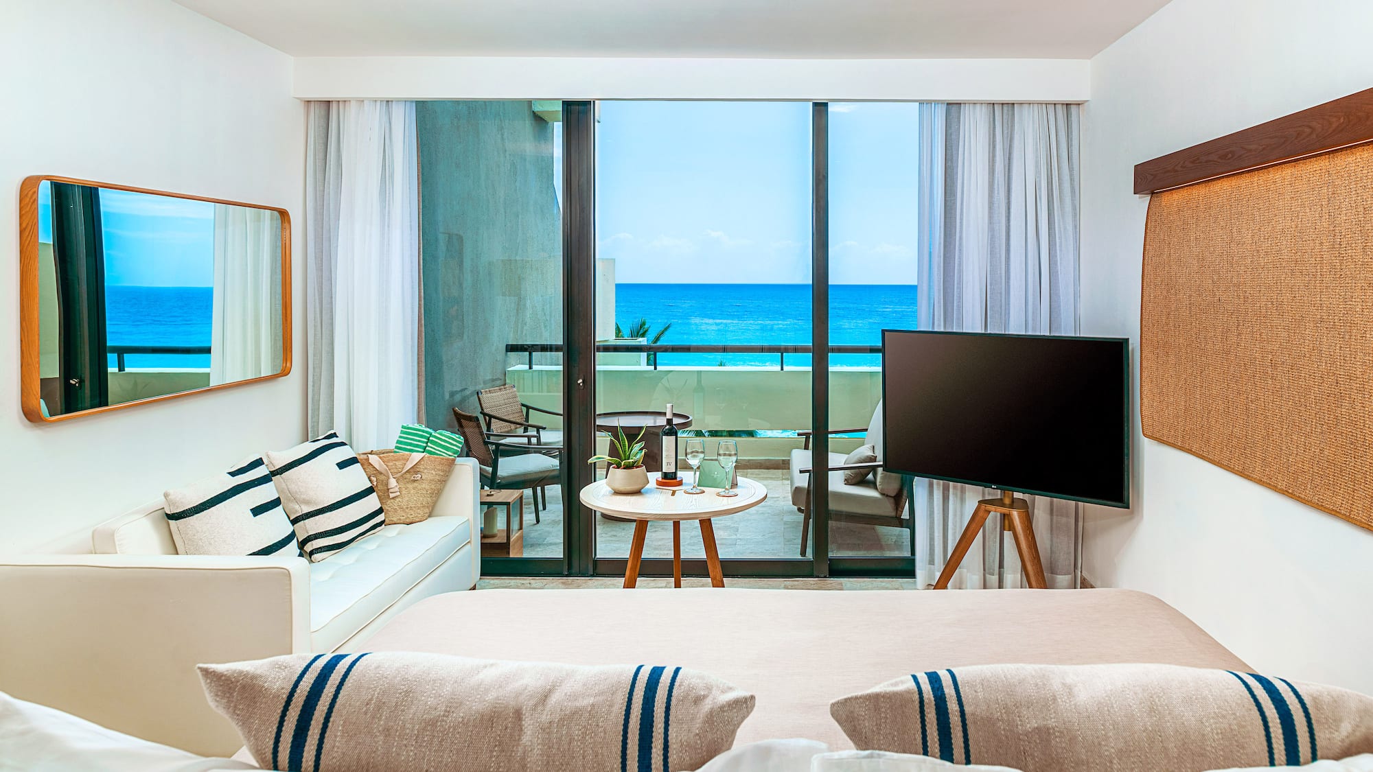 a room with a television and a view of the ocean