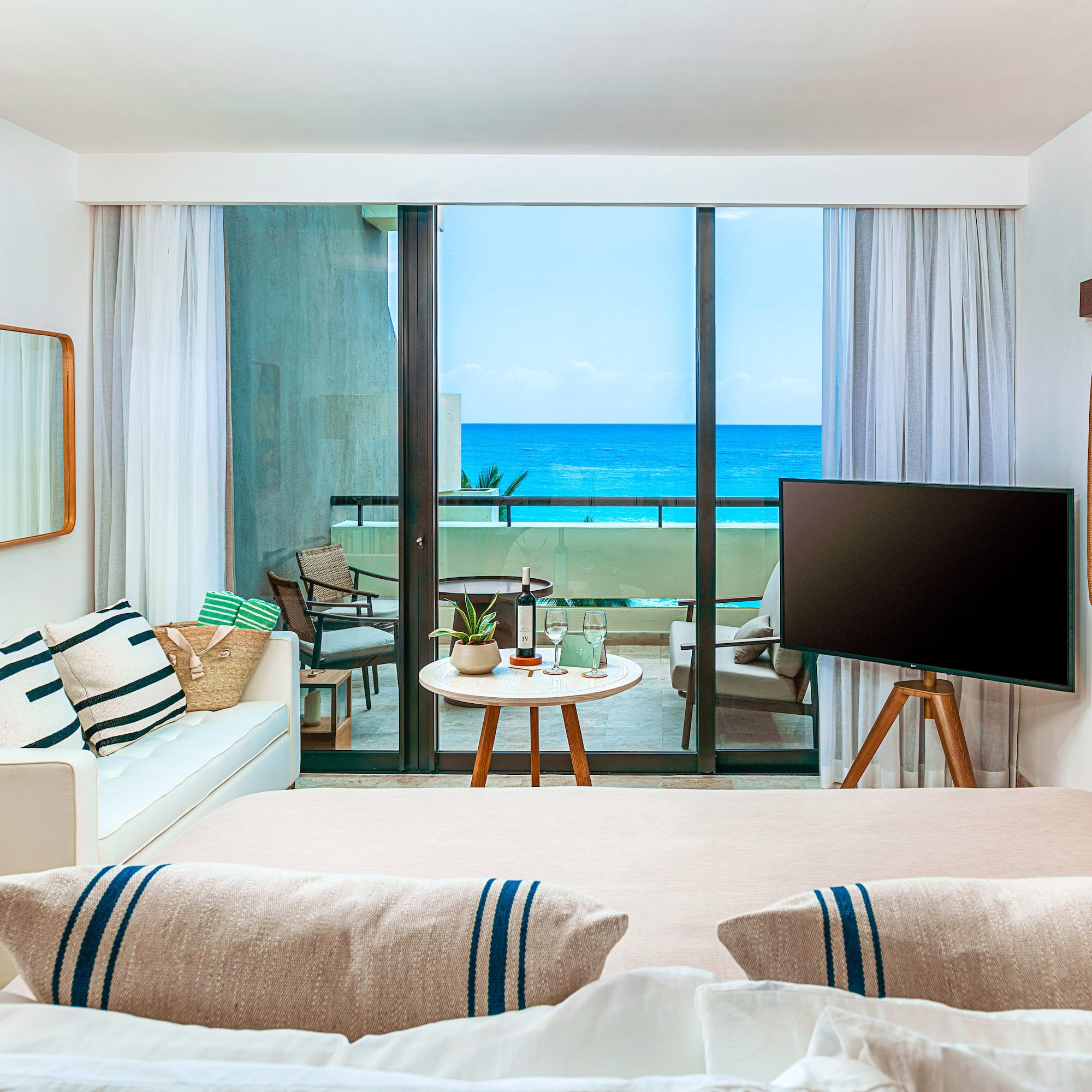 a room with a television and a view of the ocean