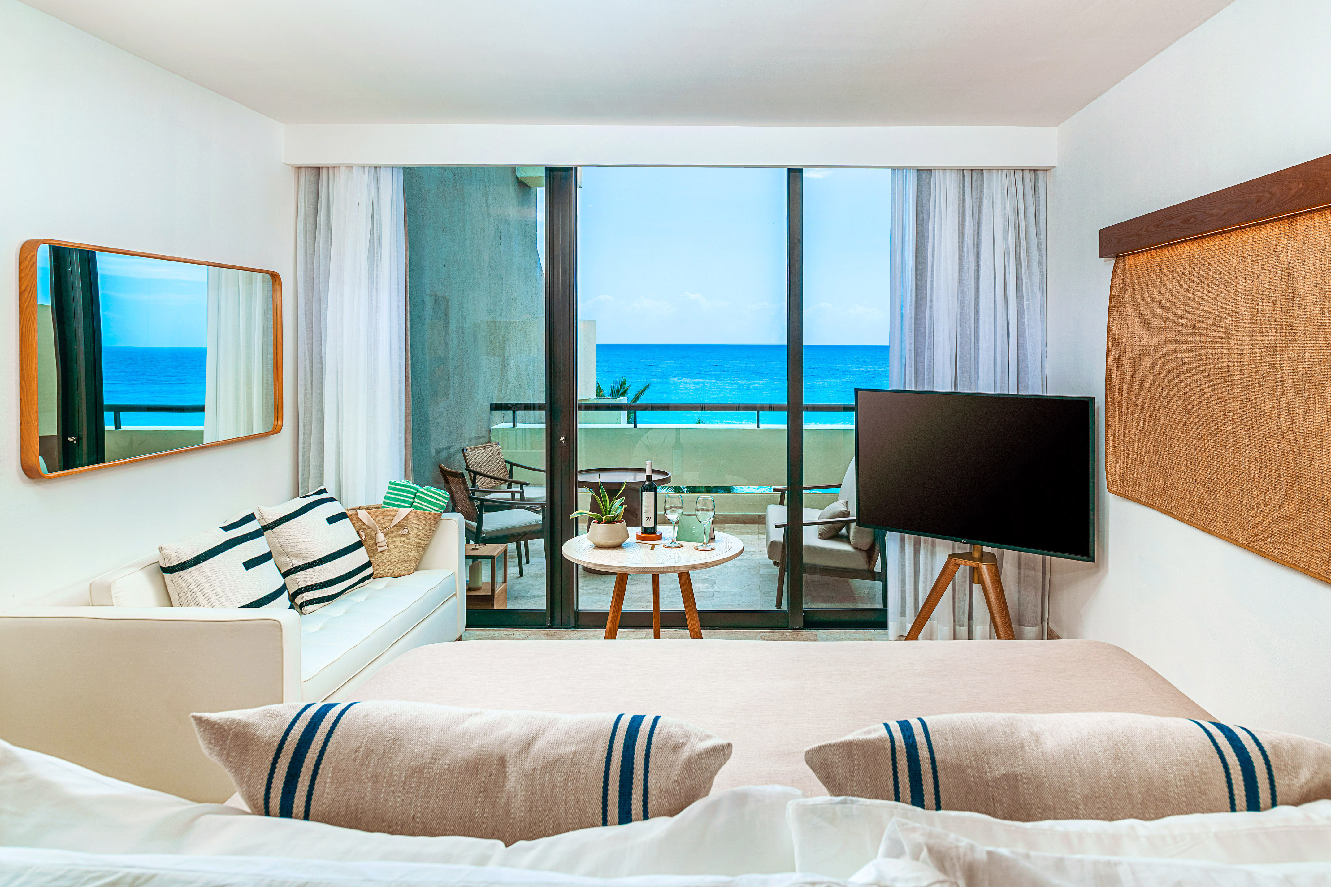 a room with a television and a view of the ocean