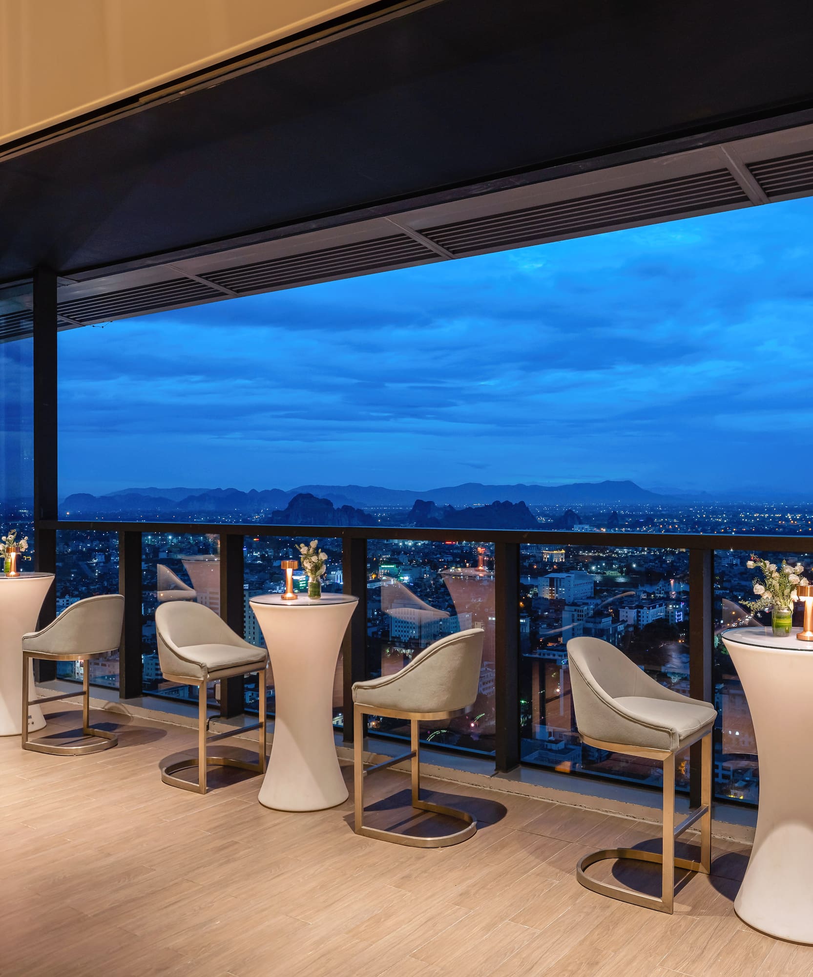 a room with tables and chairs and a view of a city