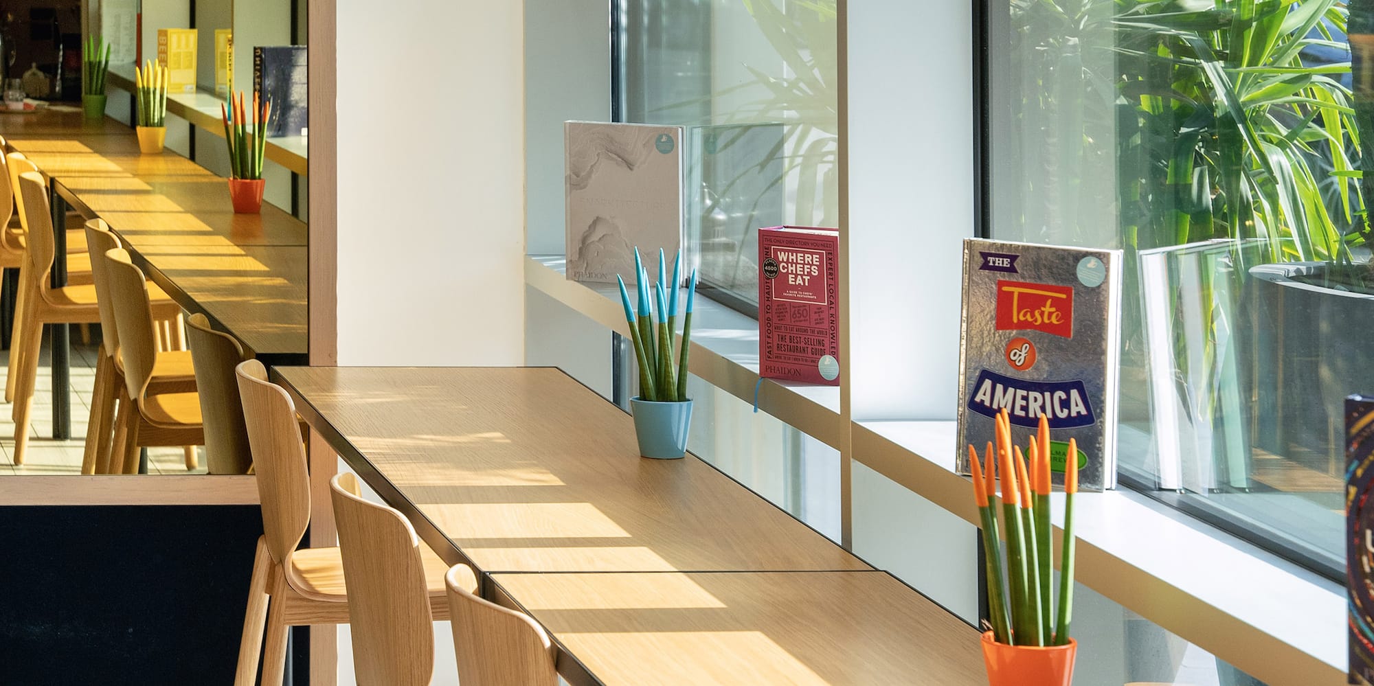 a long table with chairs and a television in the background