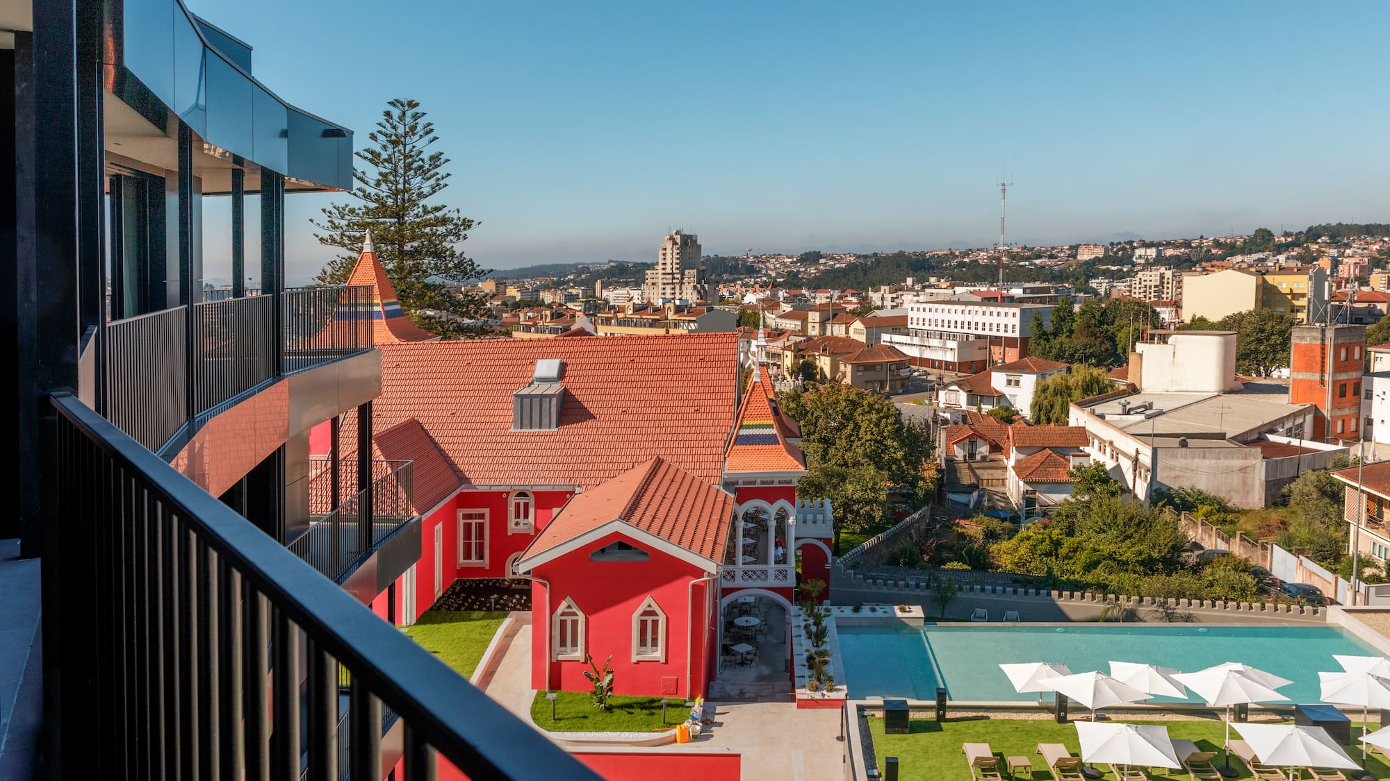 a building with a pool and lawn in a city
