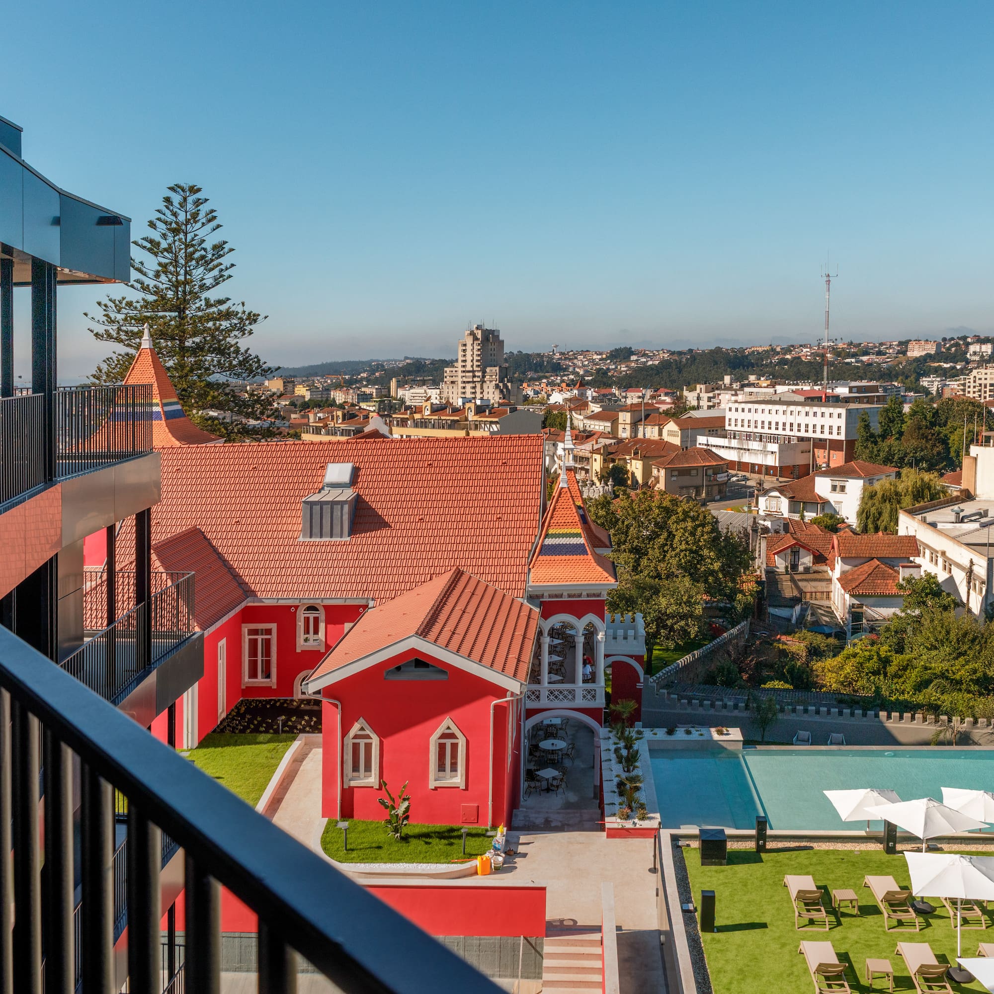 a building with a pool and lawn in a city