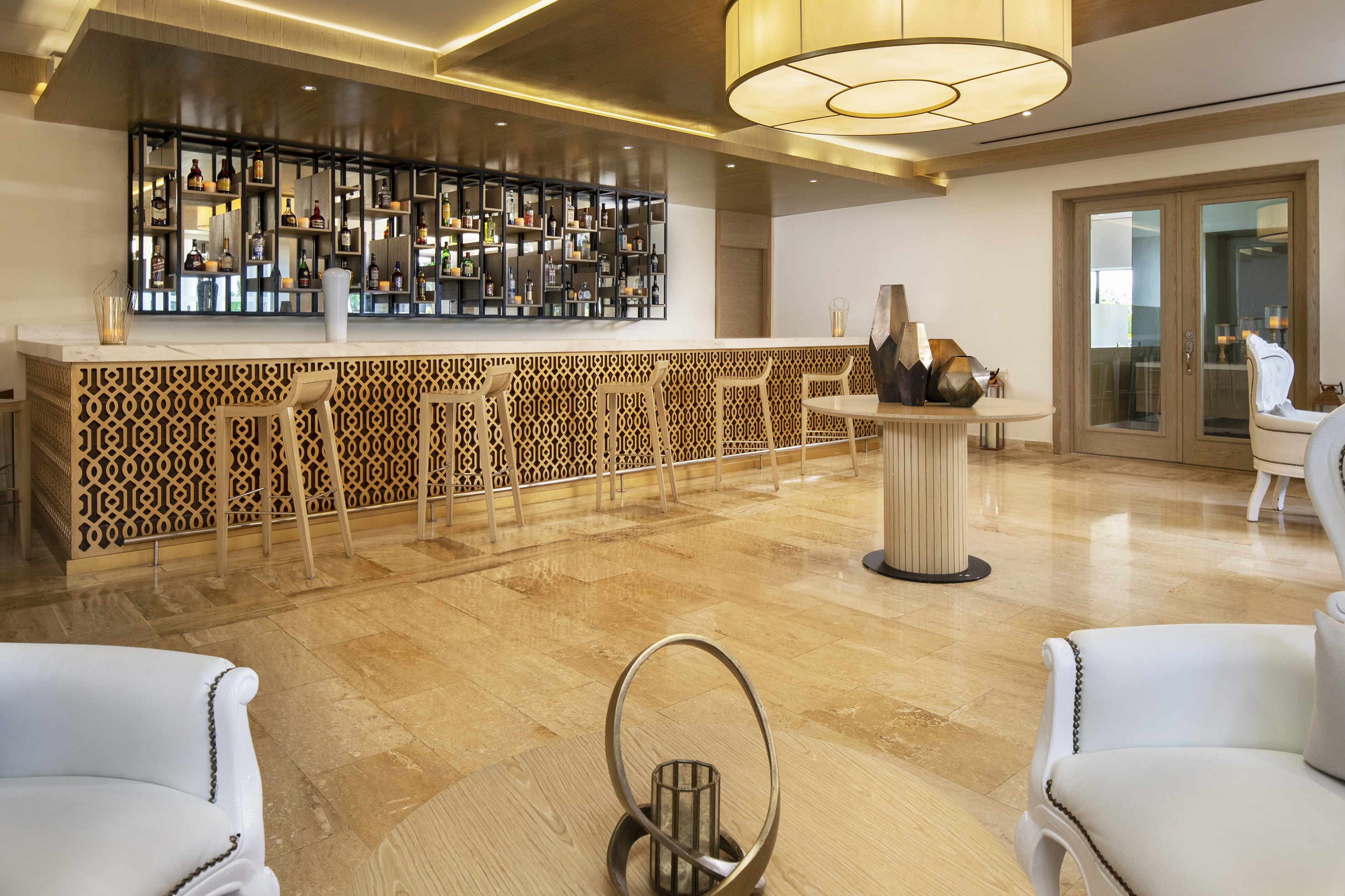 Luxury hotel lobby bar with intricate wooden counter and liquor display.