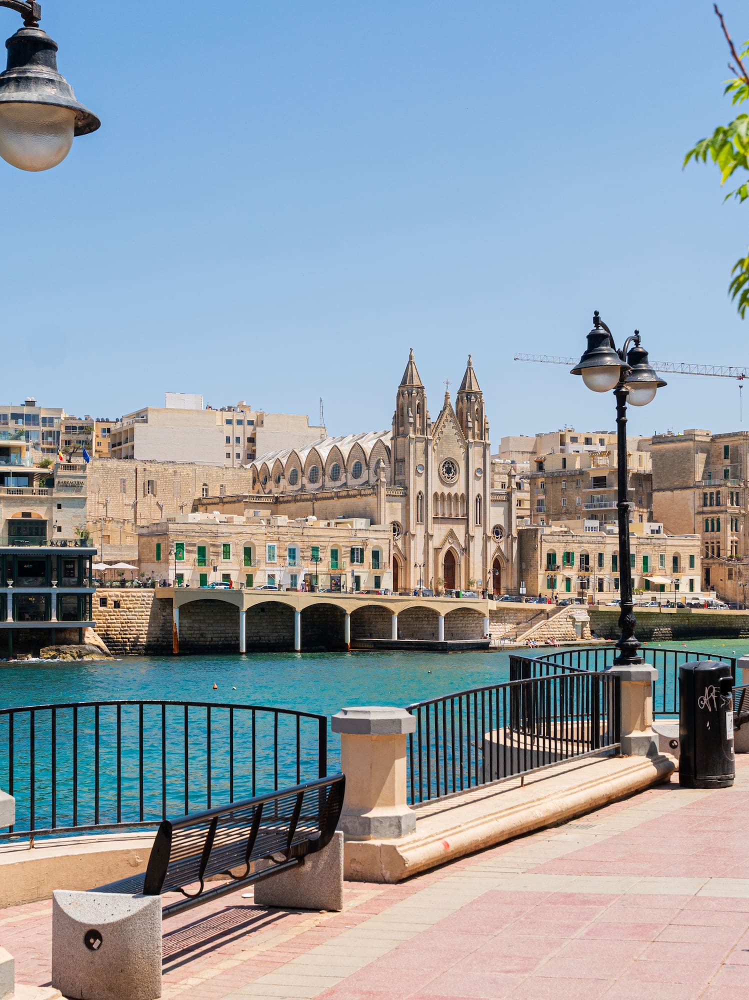 a walkway with a bridge and buildings by the water