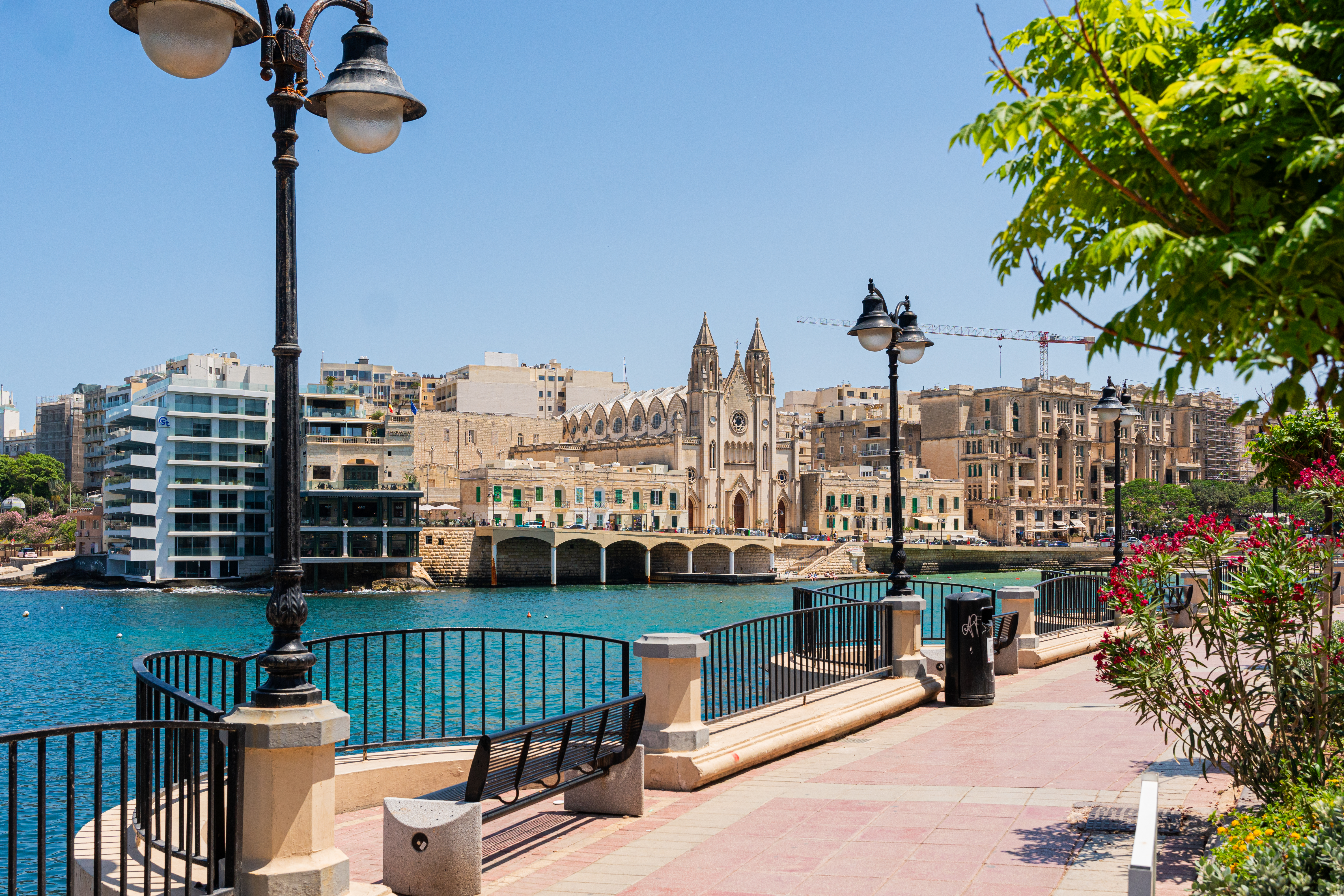 a walkway with a bridge and buildings by the water