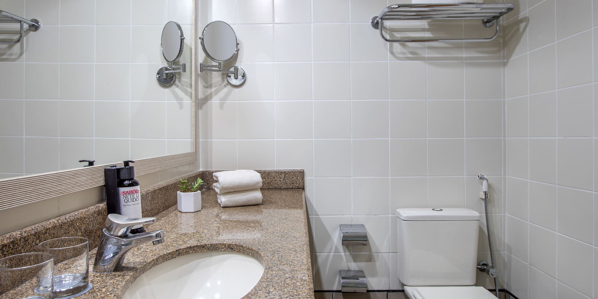 a bathroom with a marble countertop sink and toilet