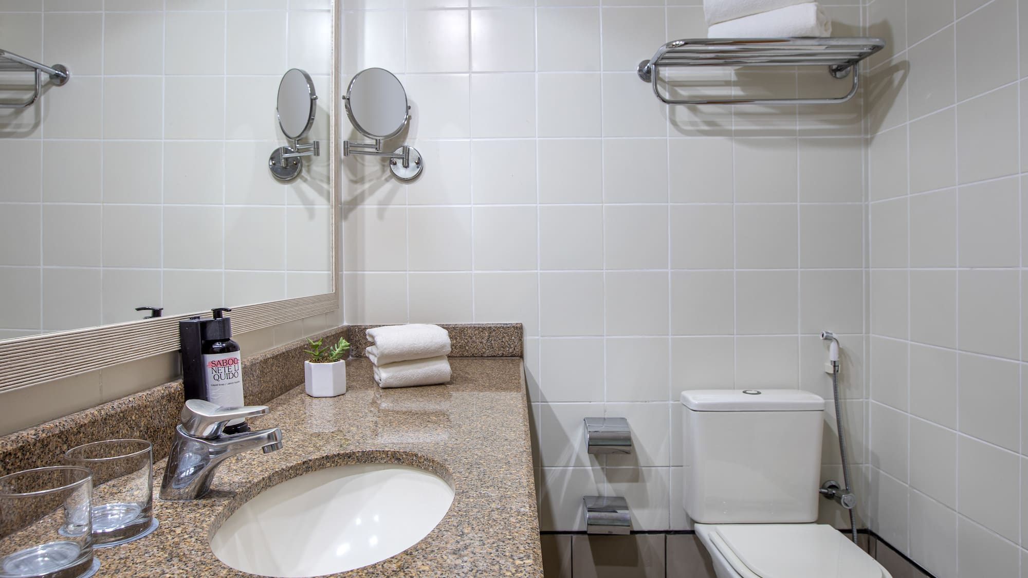 a bathroom with a marble countertop sink and toilet