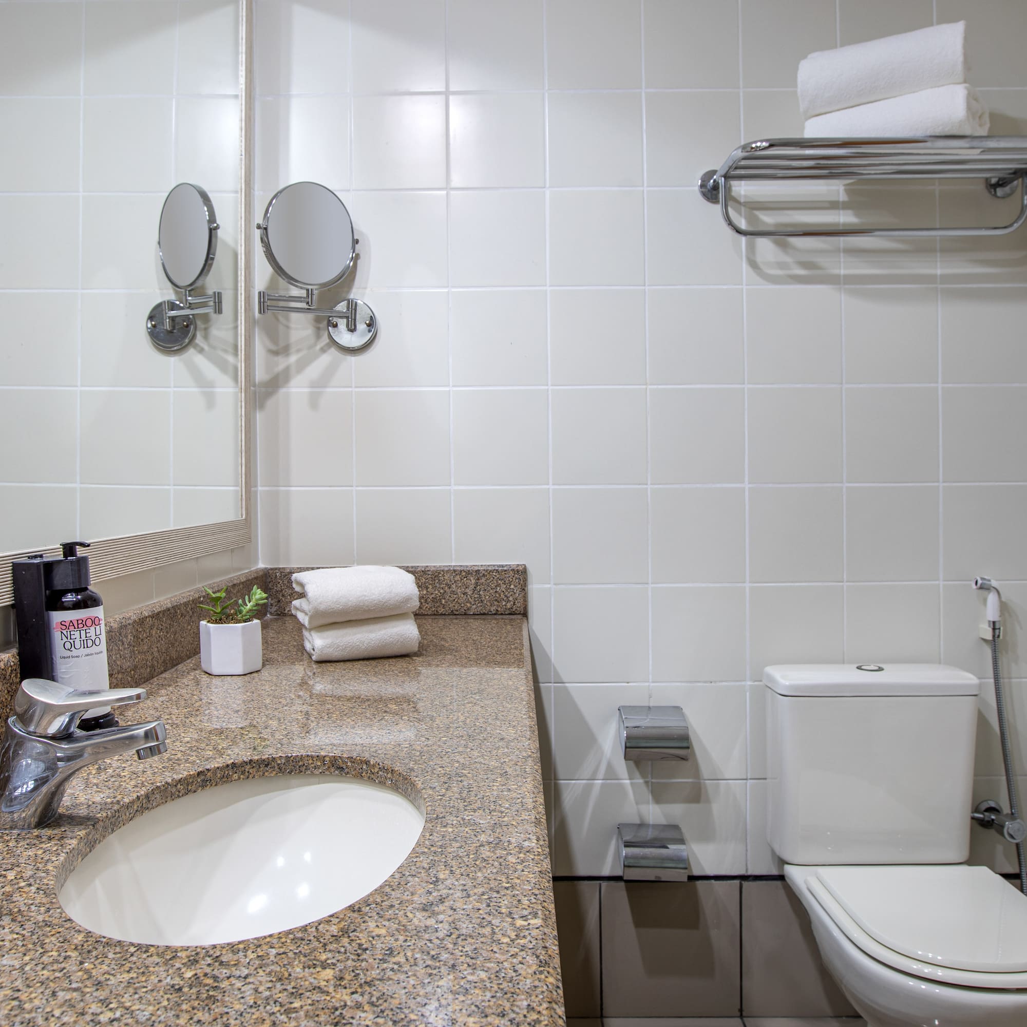 a bathroom with a marble countertop sink and toilet