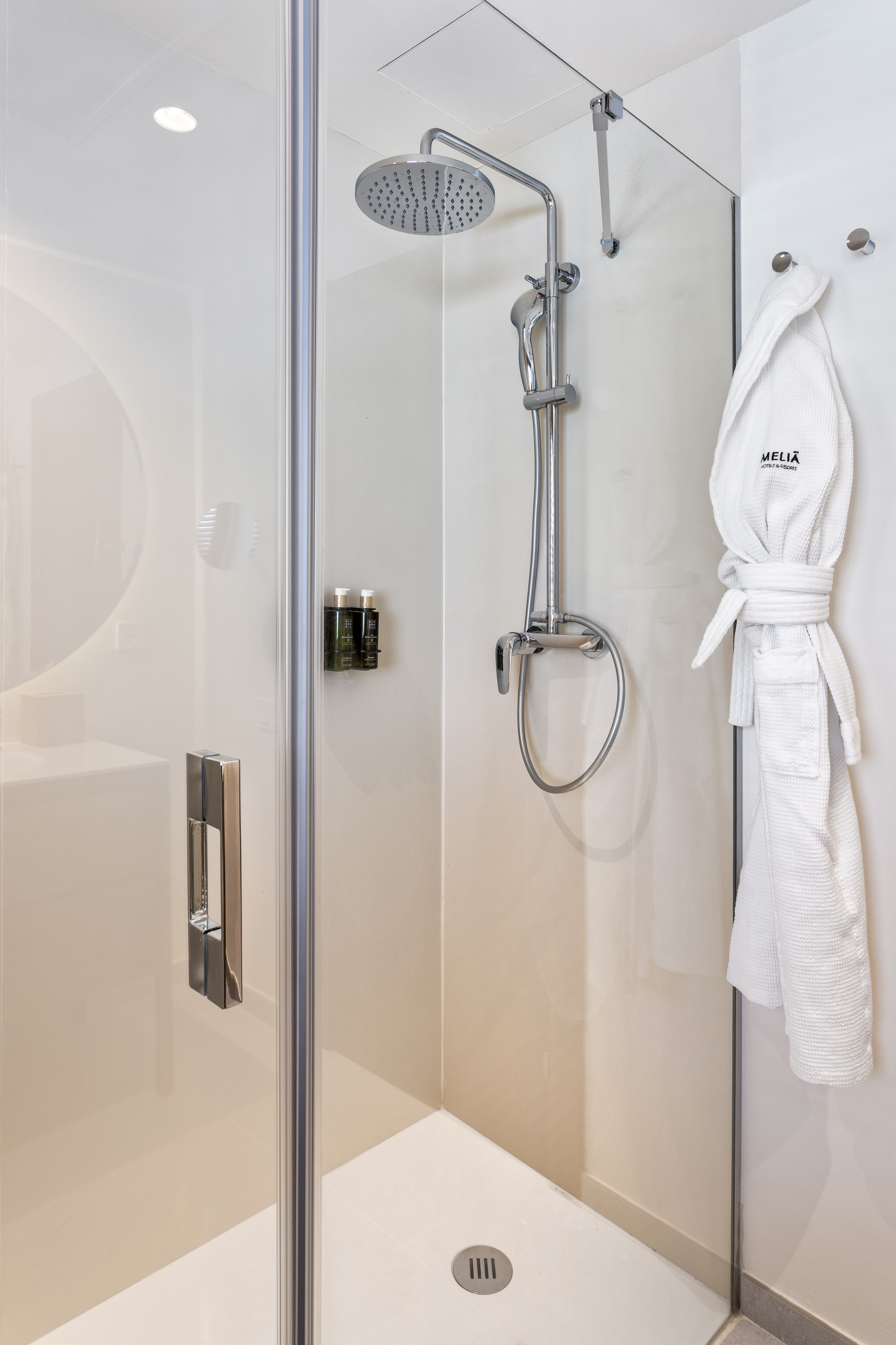 a shower with a white robe on a hook