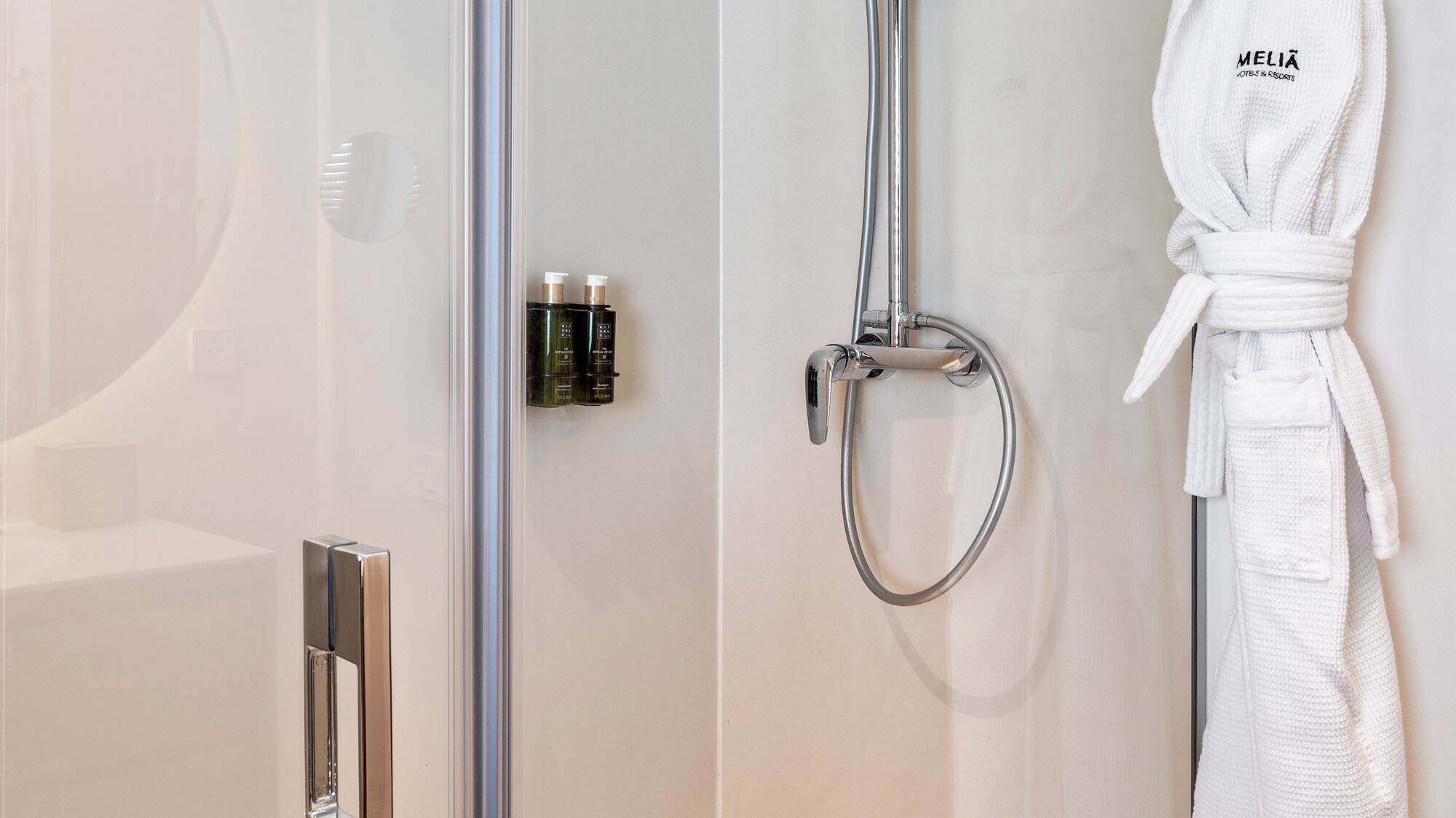 a shower with a white robe on a hook