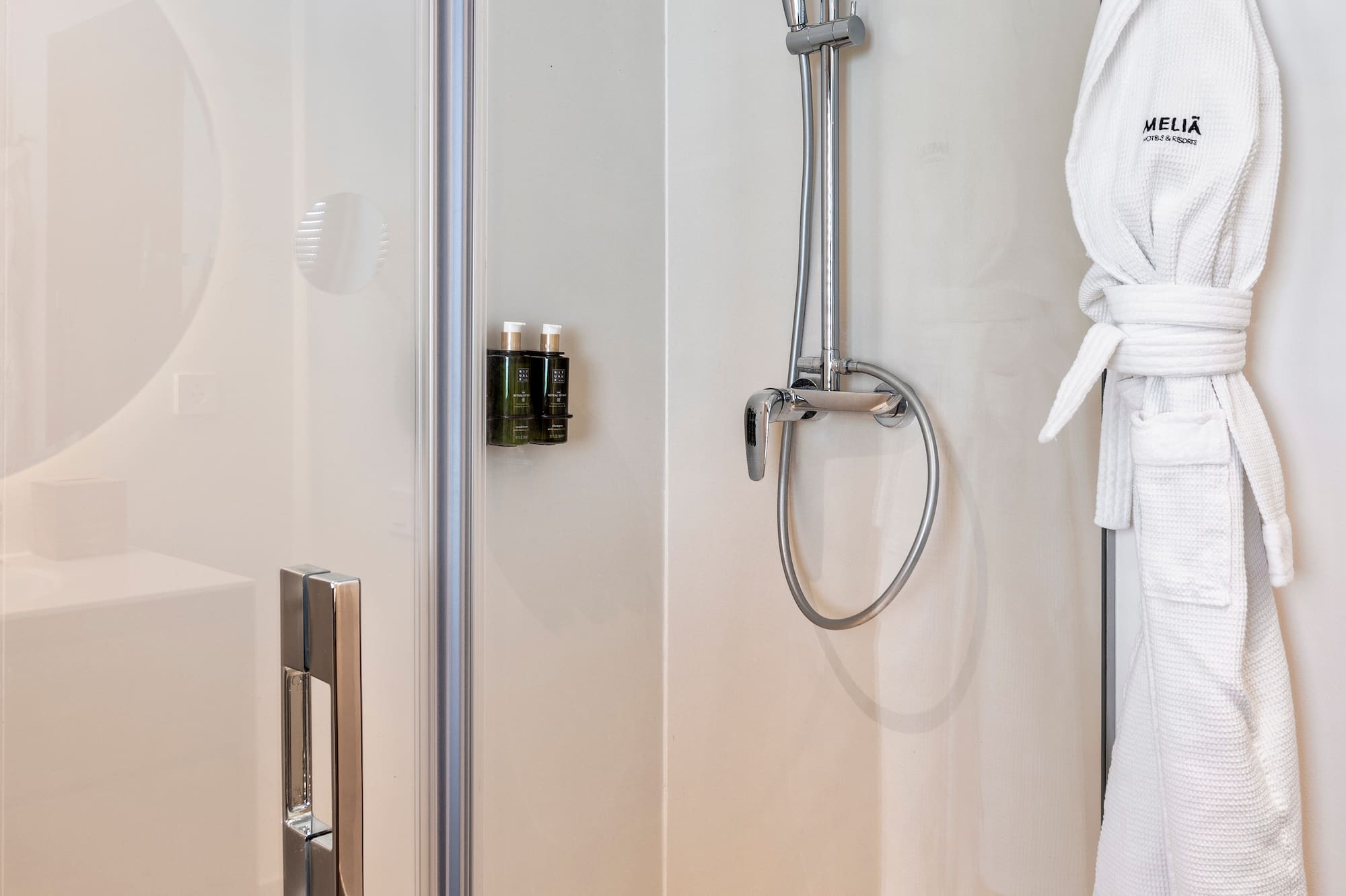 a shower with a white robe on a hook