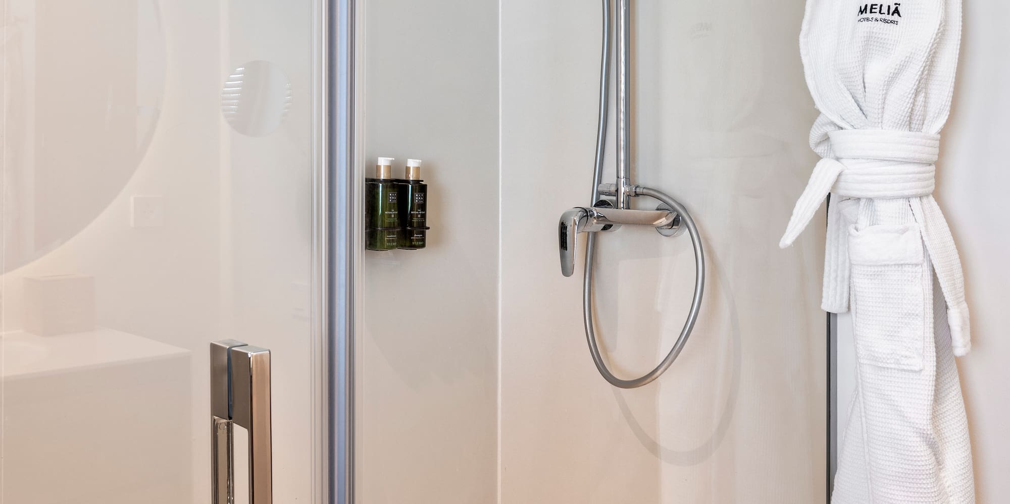 a shower with a white robe on a hook