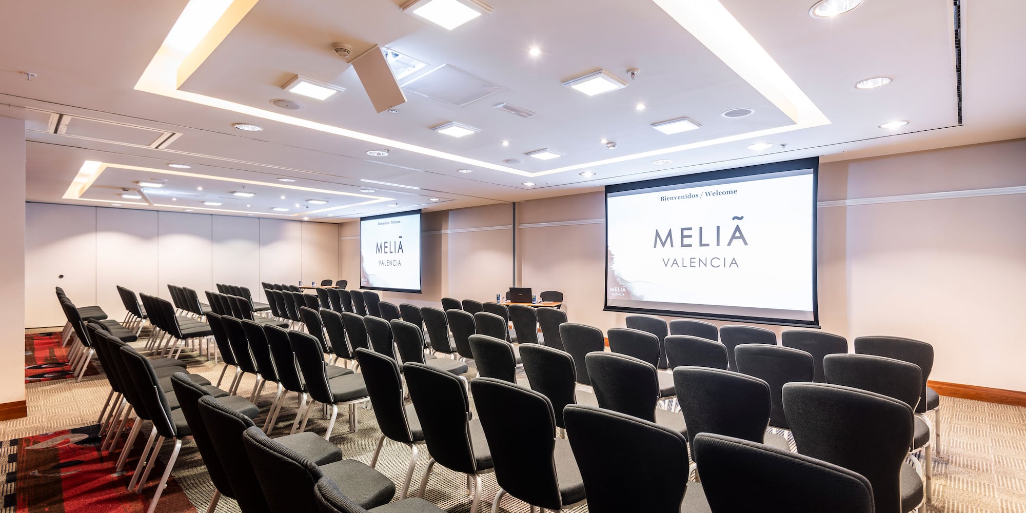 a room with rows of chairs and a projector screen