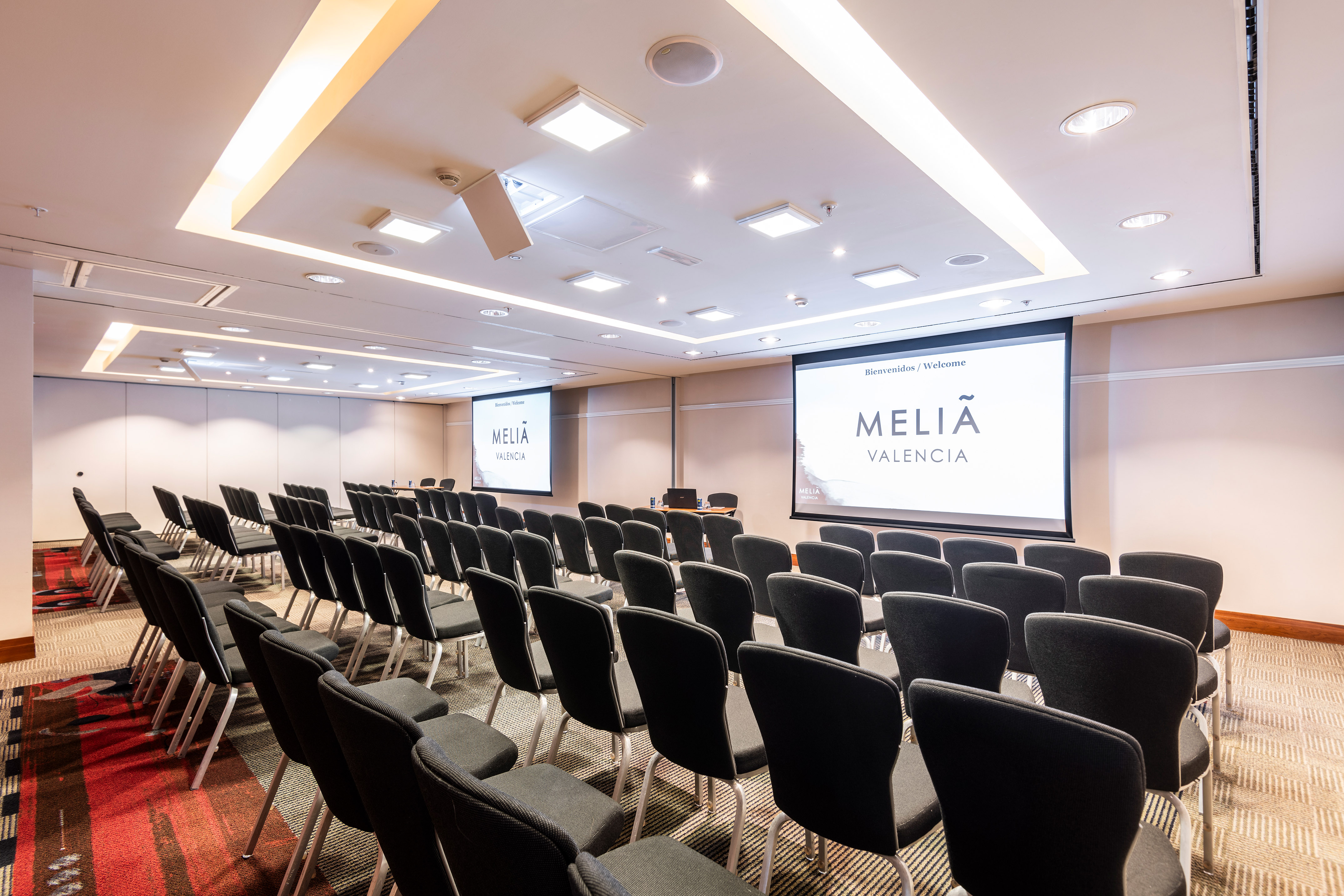 a room with rows of chairs and a projector screen