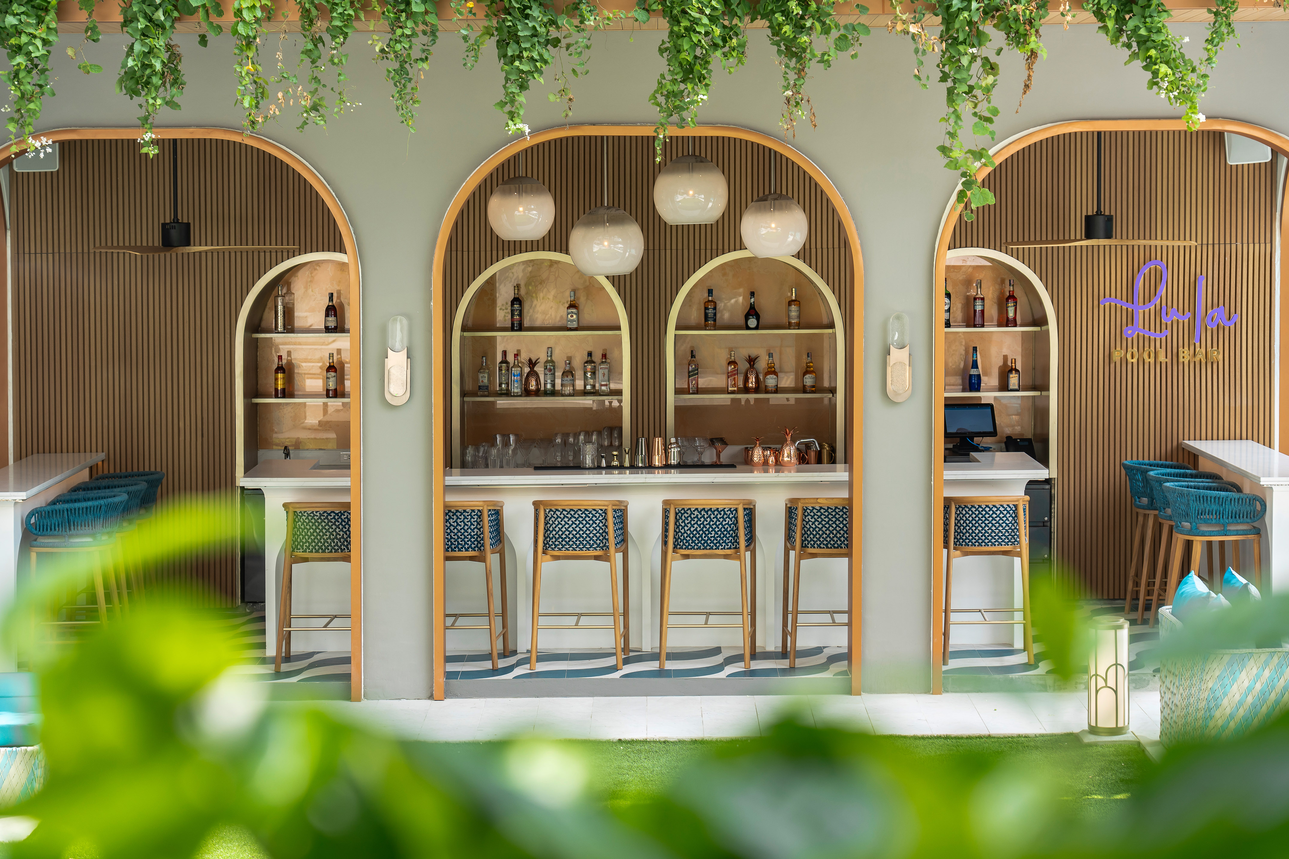 Modern outdoor pool bar, arched wood design, liquor shelves, hanging plants. - Lula Pool Bar, Ẩm thực Quốc tế - Meliá Pattaya Hotel, Pattaya