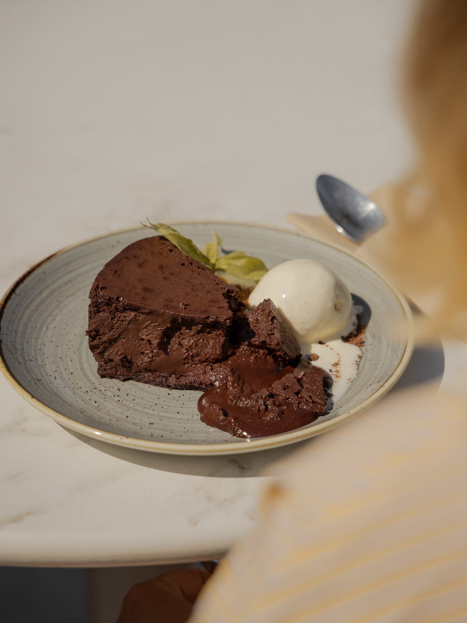 Gooey chocolate lava cake with vanilla ice cream and a green leaf garnish.
