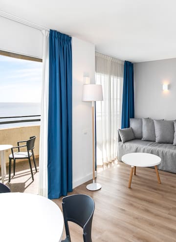 a room with a couch and table and chairs