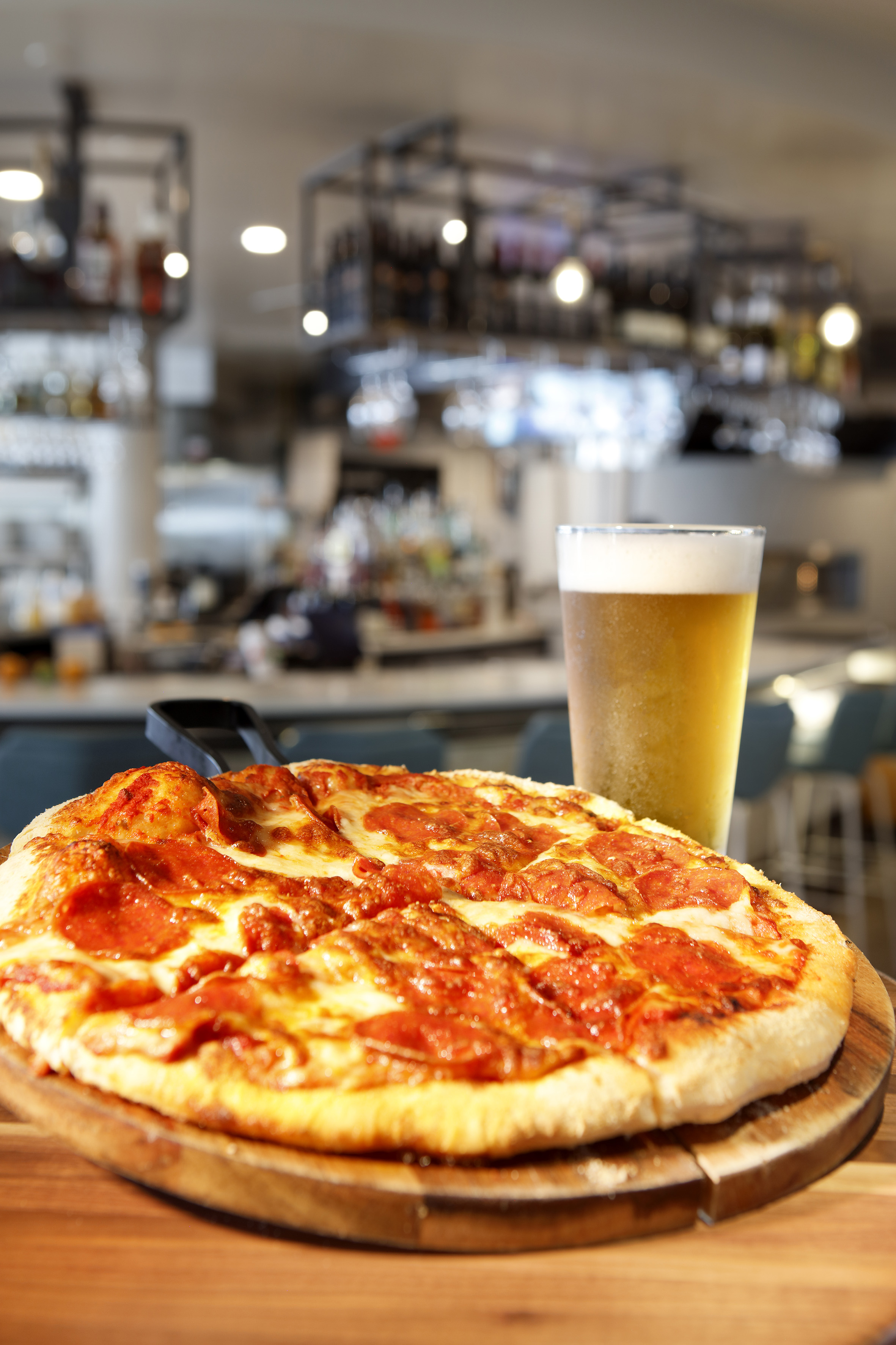 Pepperoni pizza, pint of beer on wood board at restaurant bar. - The Wilson, Cozinha internacional - Meliá Orlando Celebration, Orlando