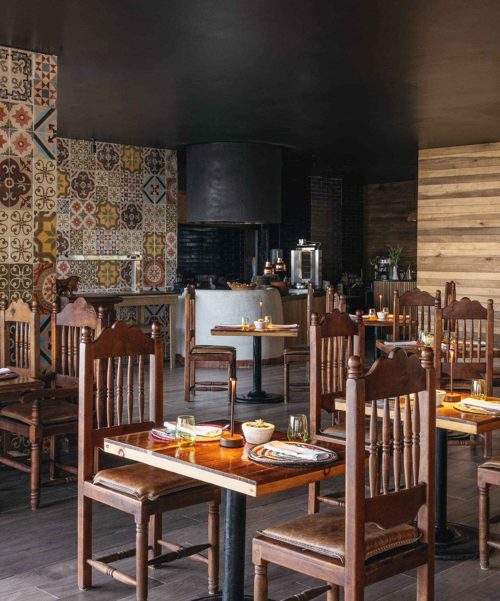 Rustic Mexican restaurant dining room with colorful tiles and wooden furniture.