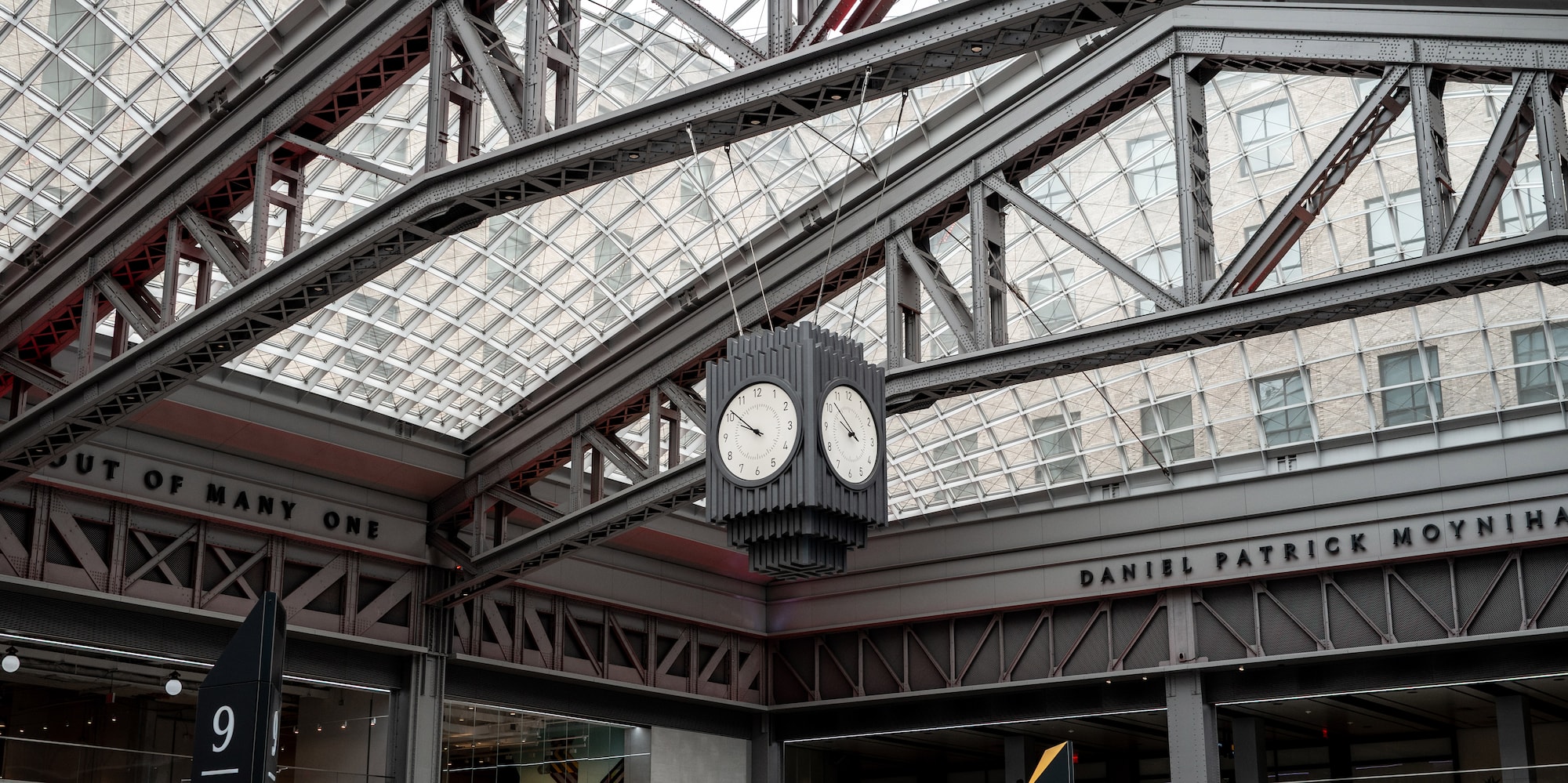 Modern Moynihan Train Hall, glass roof, steel structure, hanging clock, escalators.