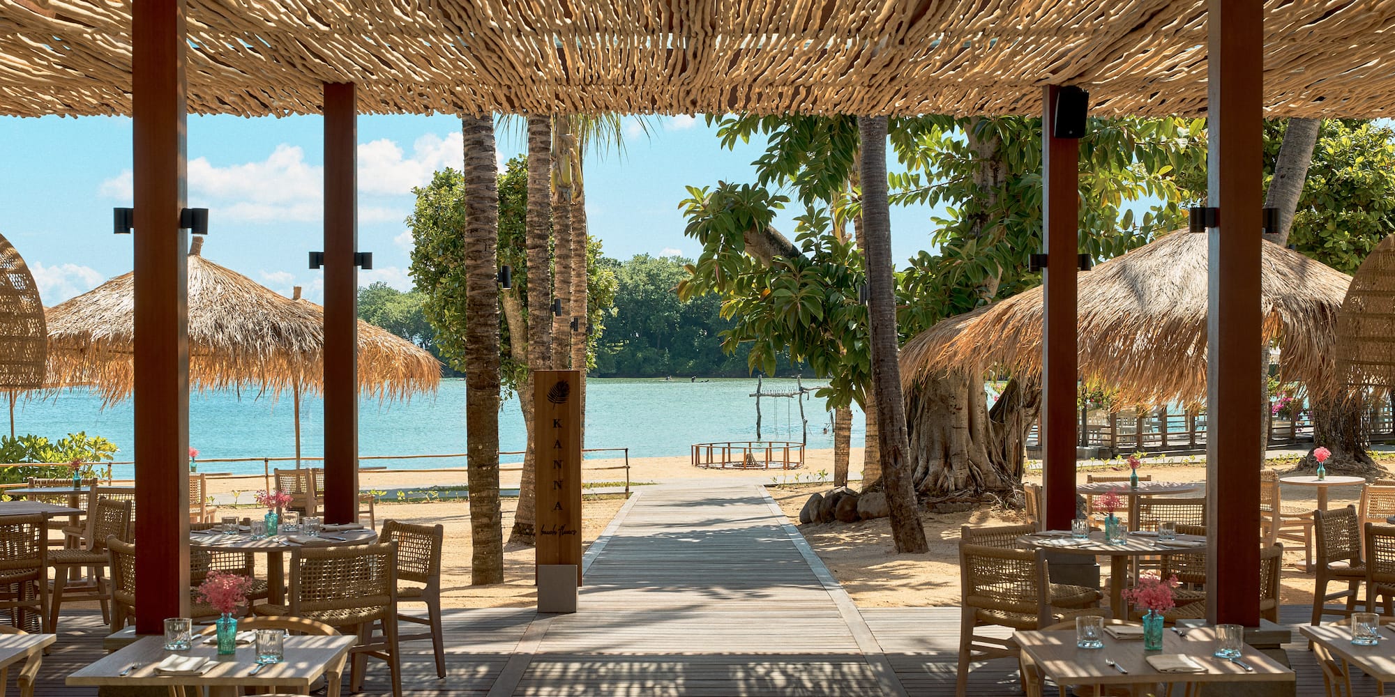 a beach restaurant with tables and chairs