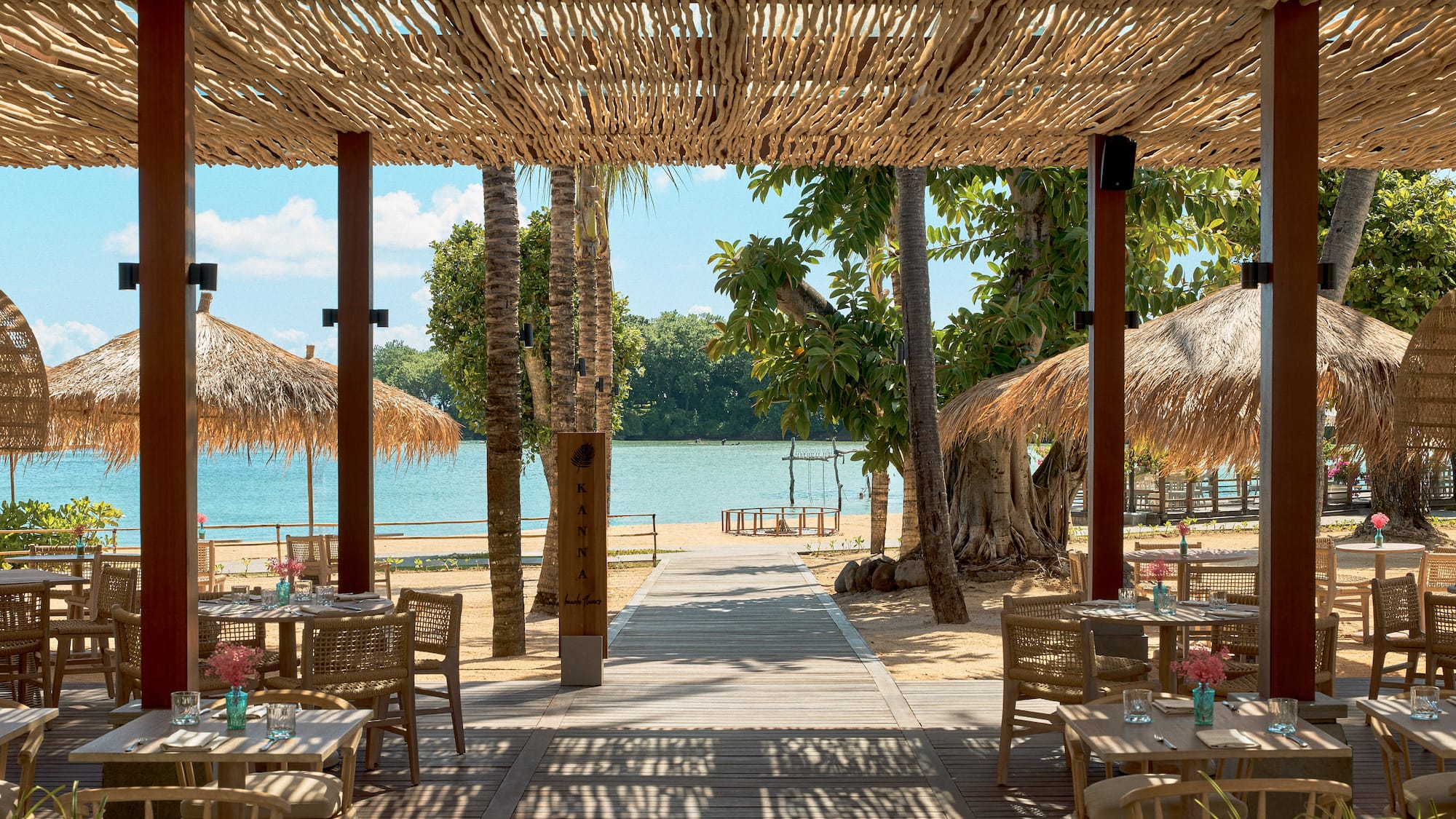 a beach restaurant with tables and chairs