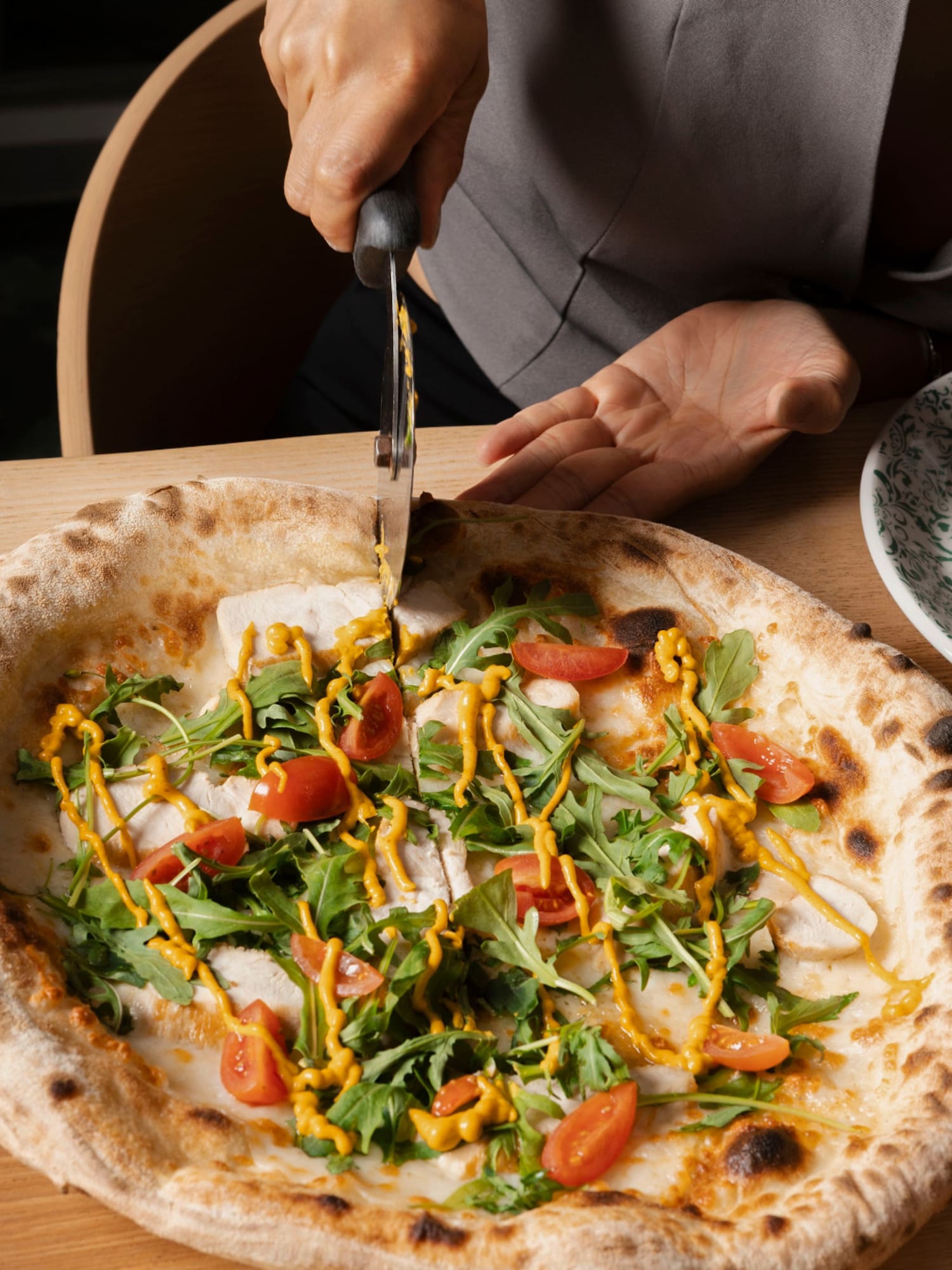 a person cutting a pizza