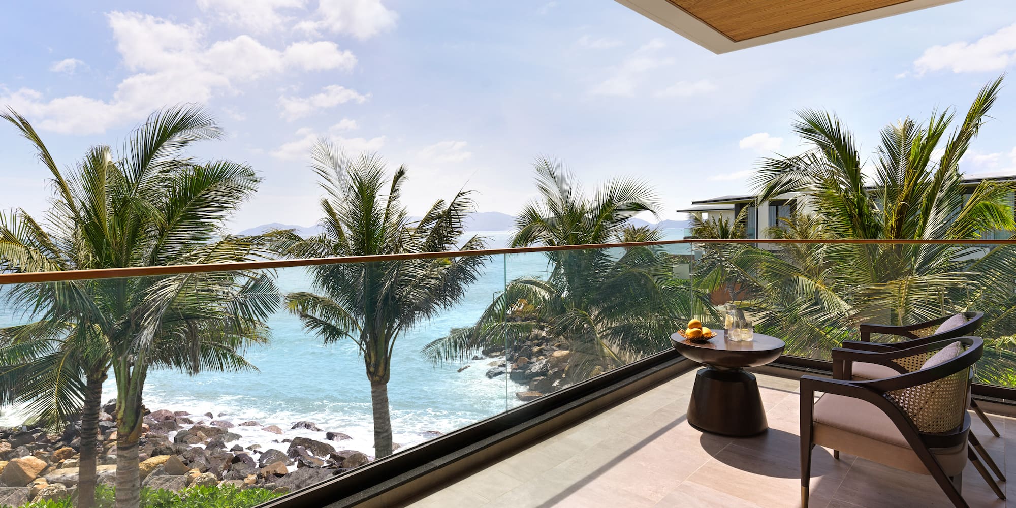 a balcony with a view of the ocean and palm trees