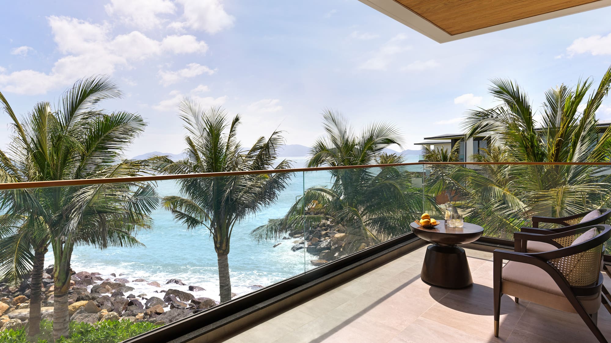a balcony with a view of the ocean and palm trees