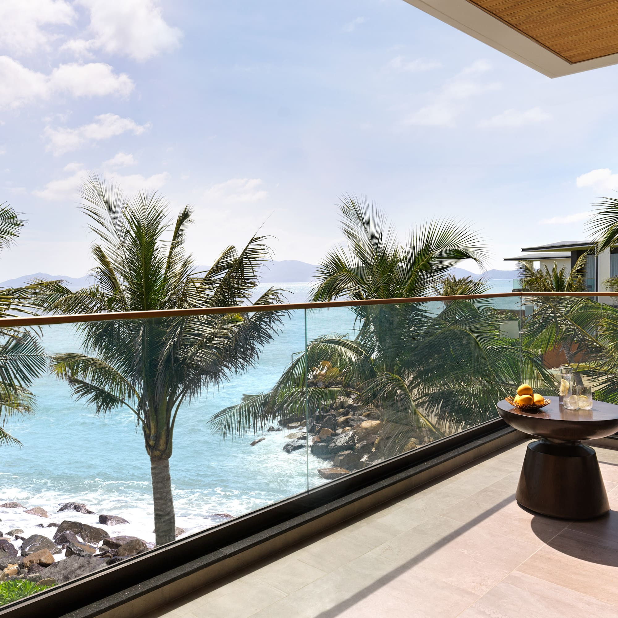 a balcony with a view of the ocean and palm trees