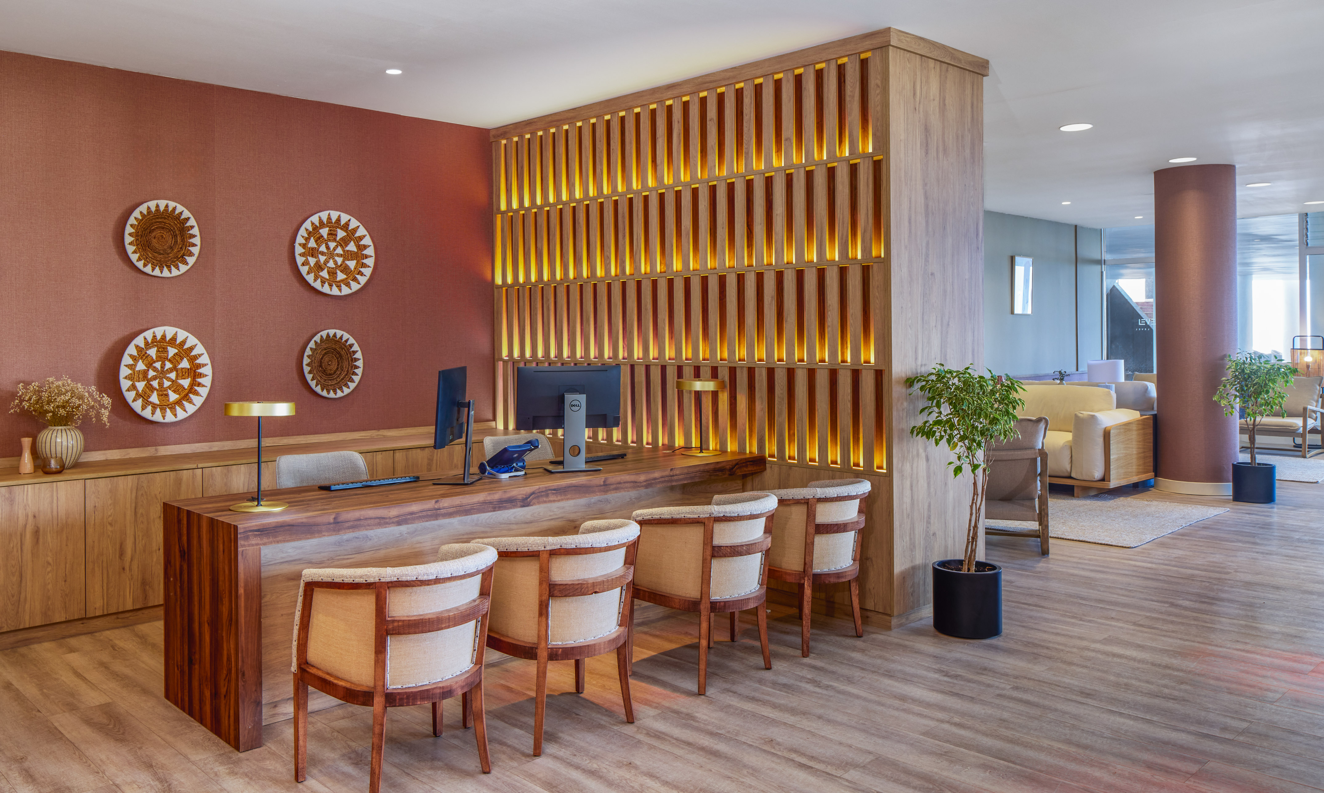 Modern wooden hotel reception desk with warm lighting and a stylish lobby.