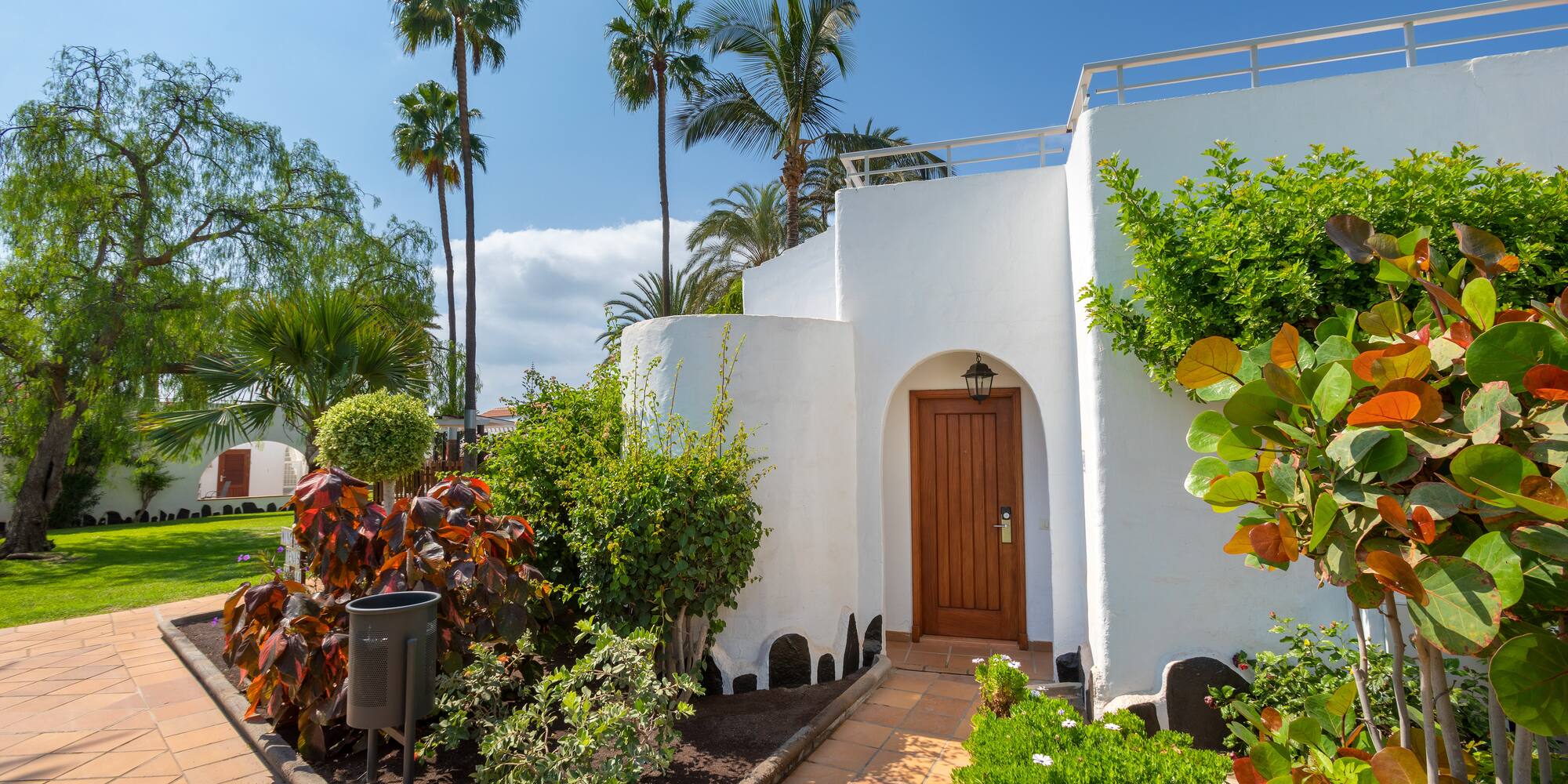 a white building with a door and trees
