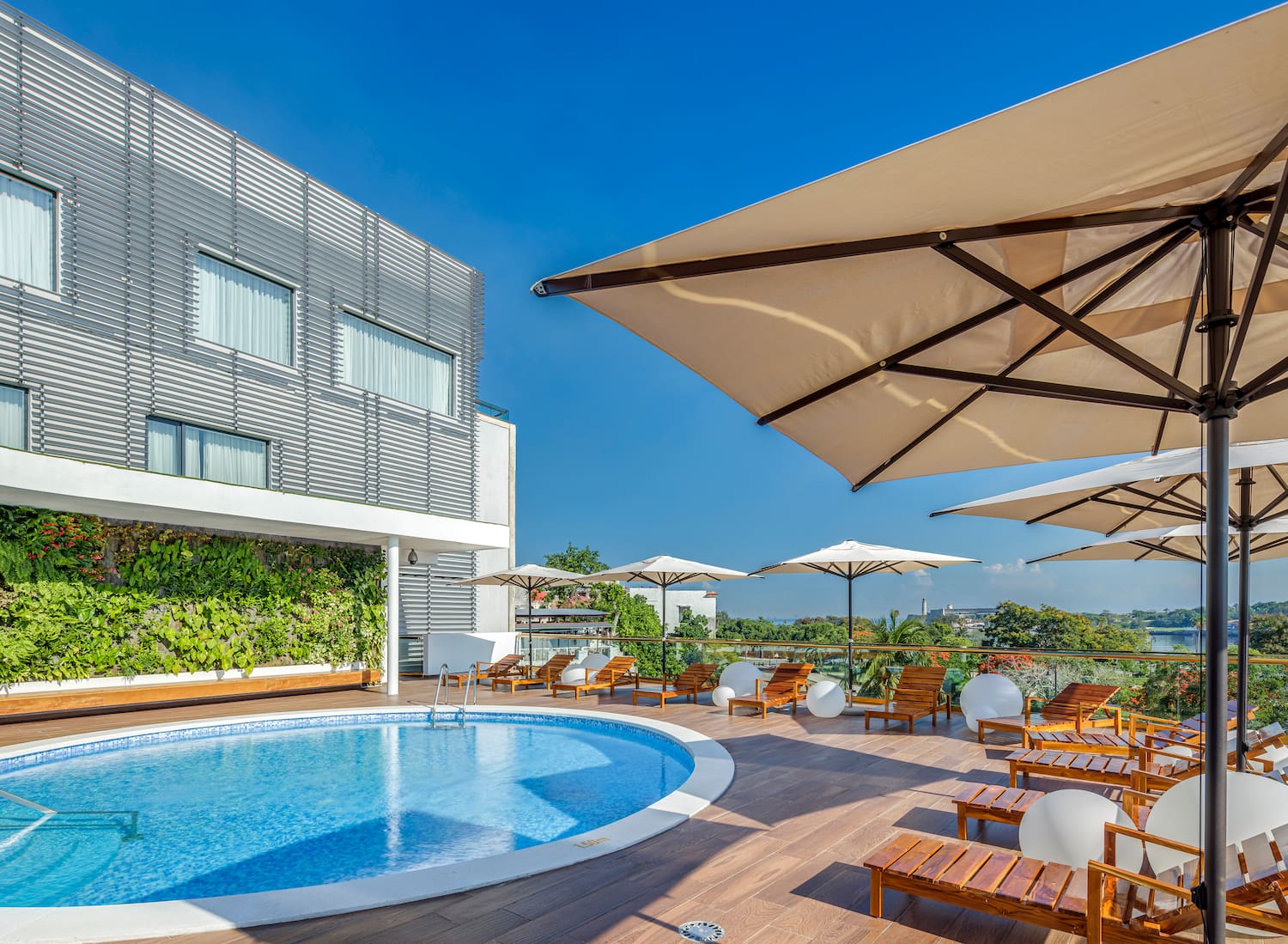 a pool with chairs and umbrellas on a deck