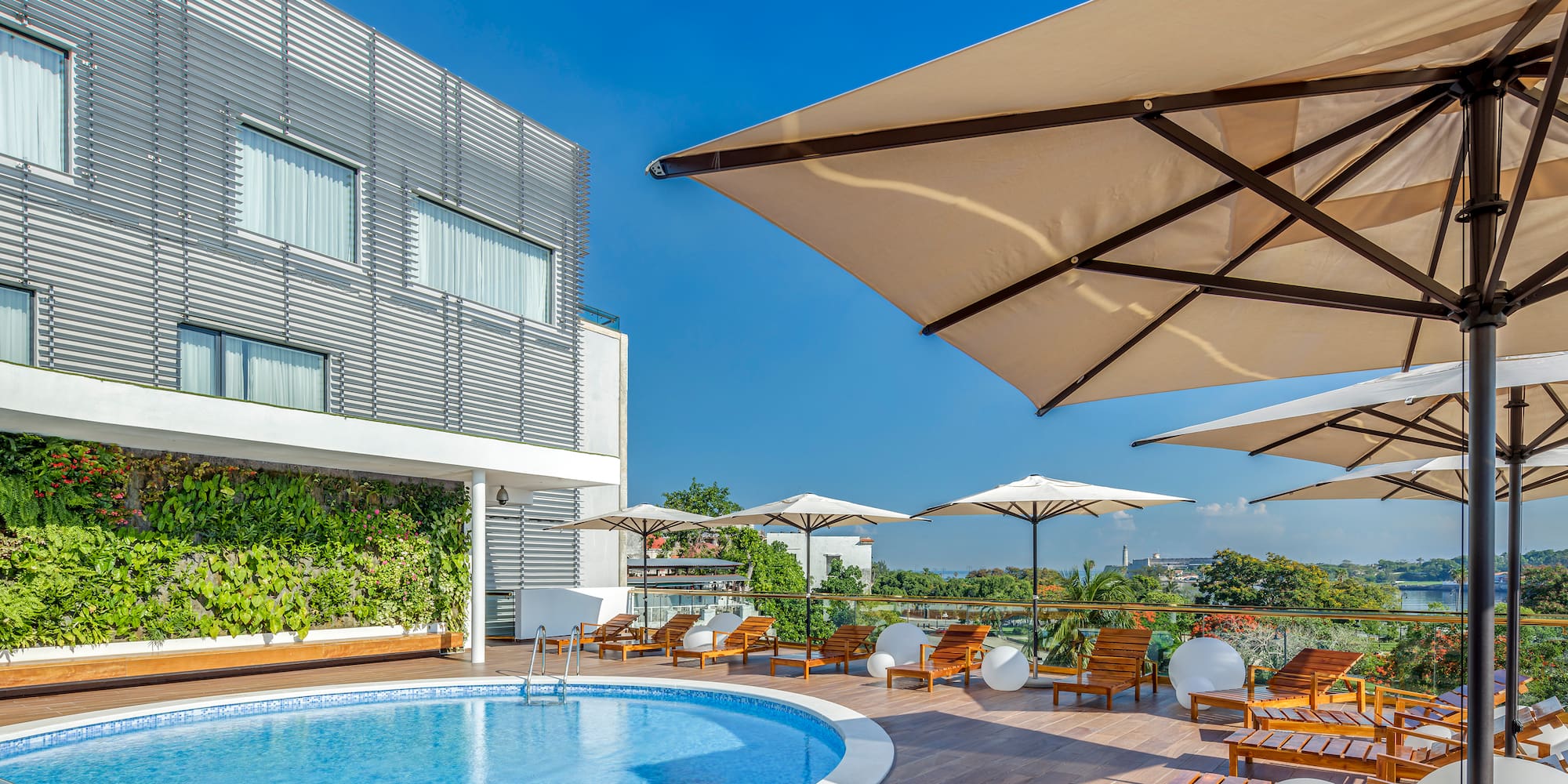 a pool with chairs and umbrellas on a deck