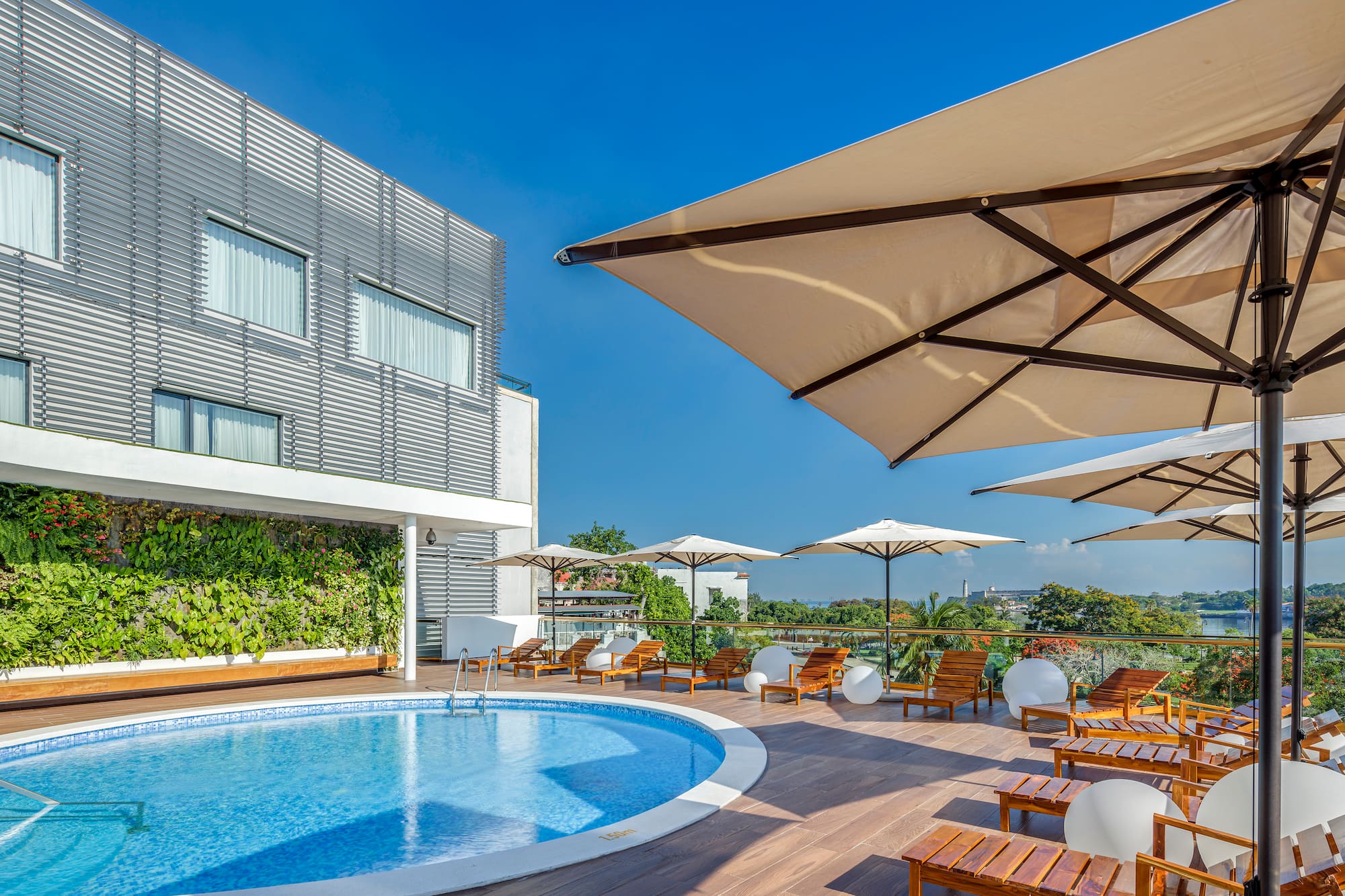 a pool with chairs and umbrellas on a deck