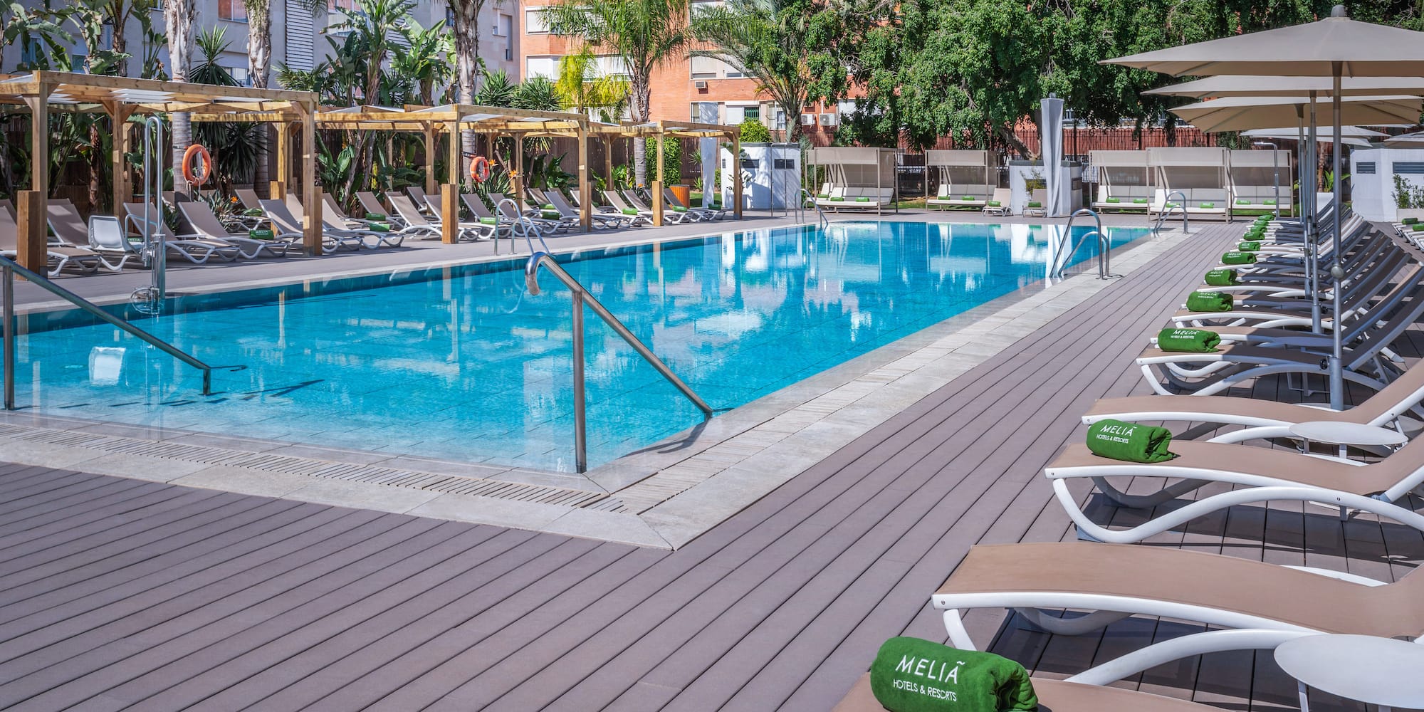 a pool with lounge chairs and a wood deck