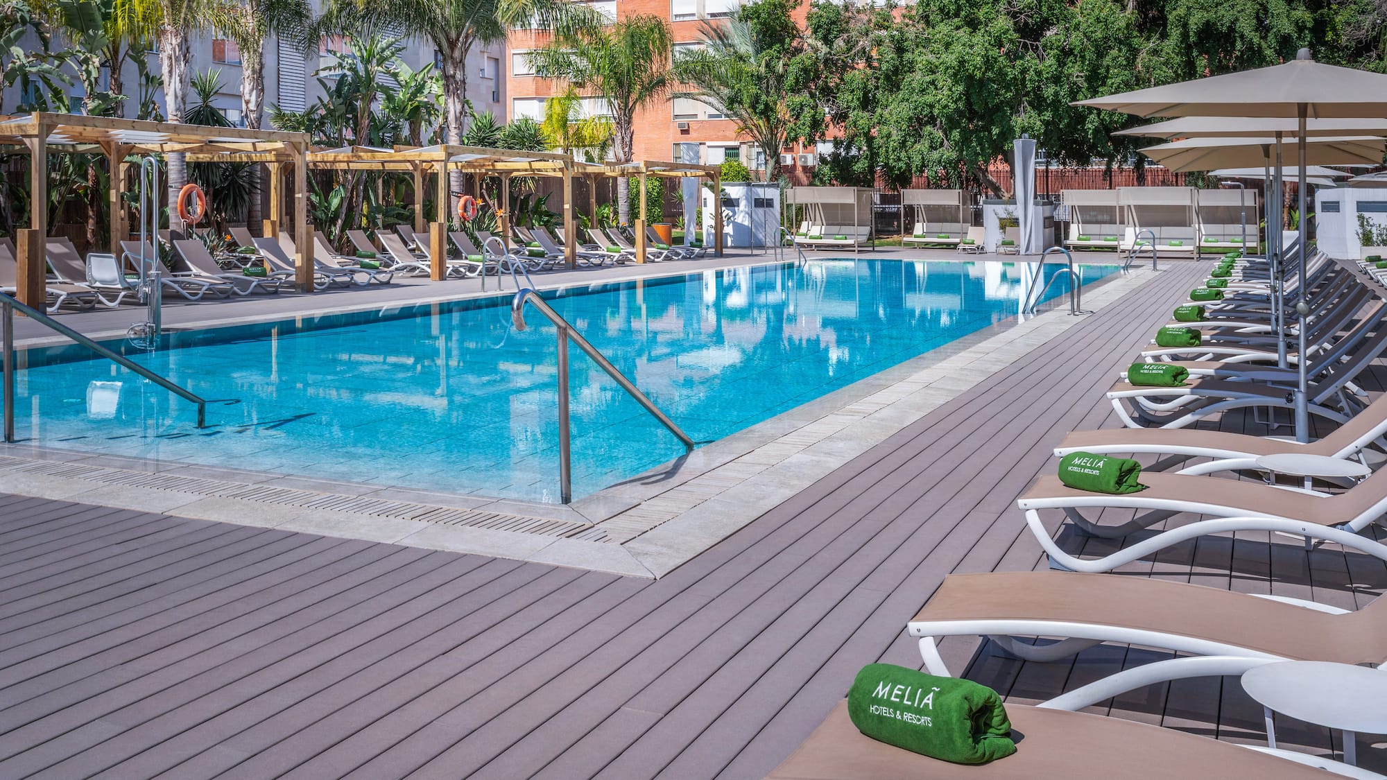 a pool with lounge chairs and a wood deck