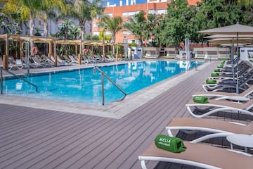 a pool with lounge chairs and a wood deck