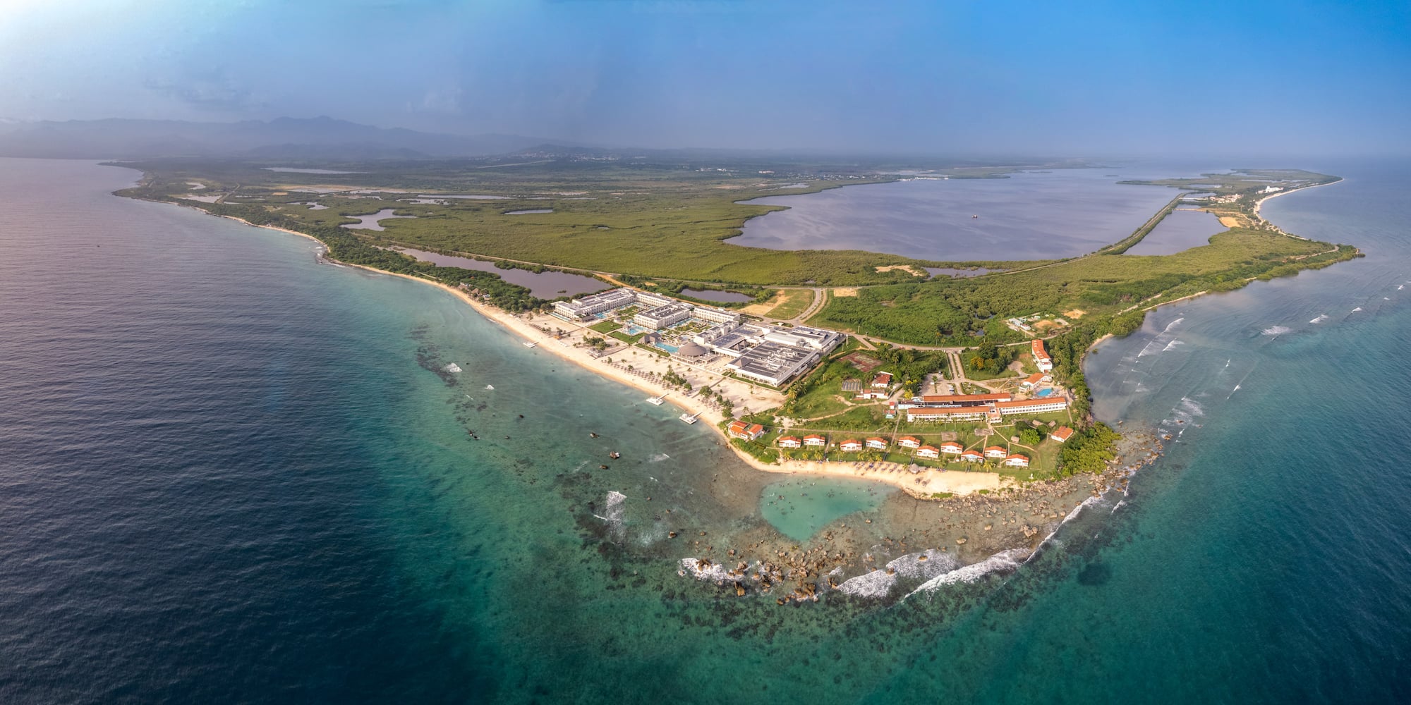 an aerial view of a beach with buildings and a body of water