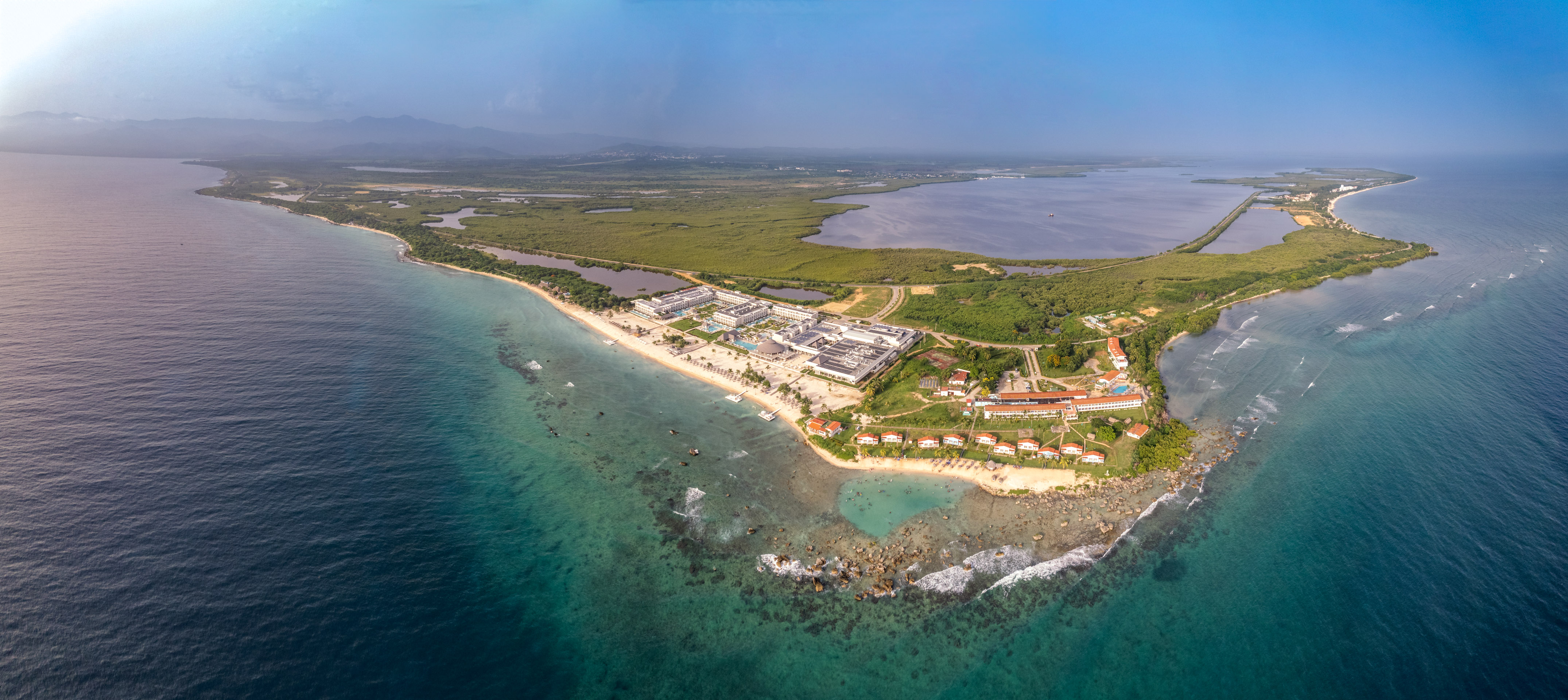 an aerial view of a beach with buildings and a body of water