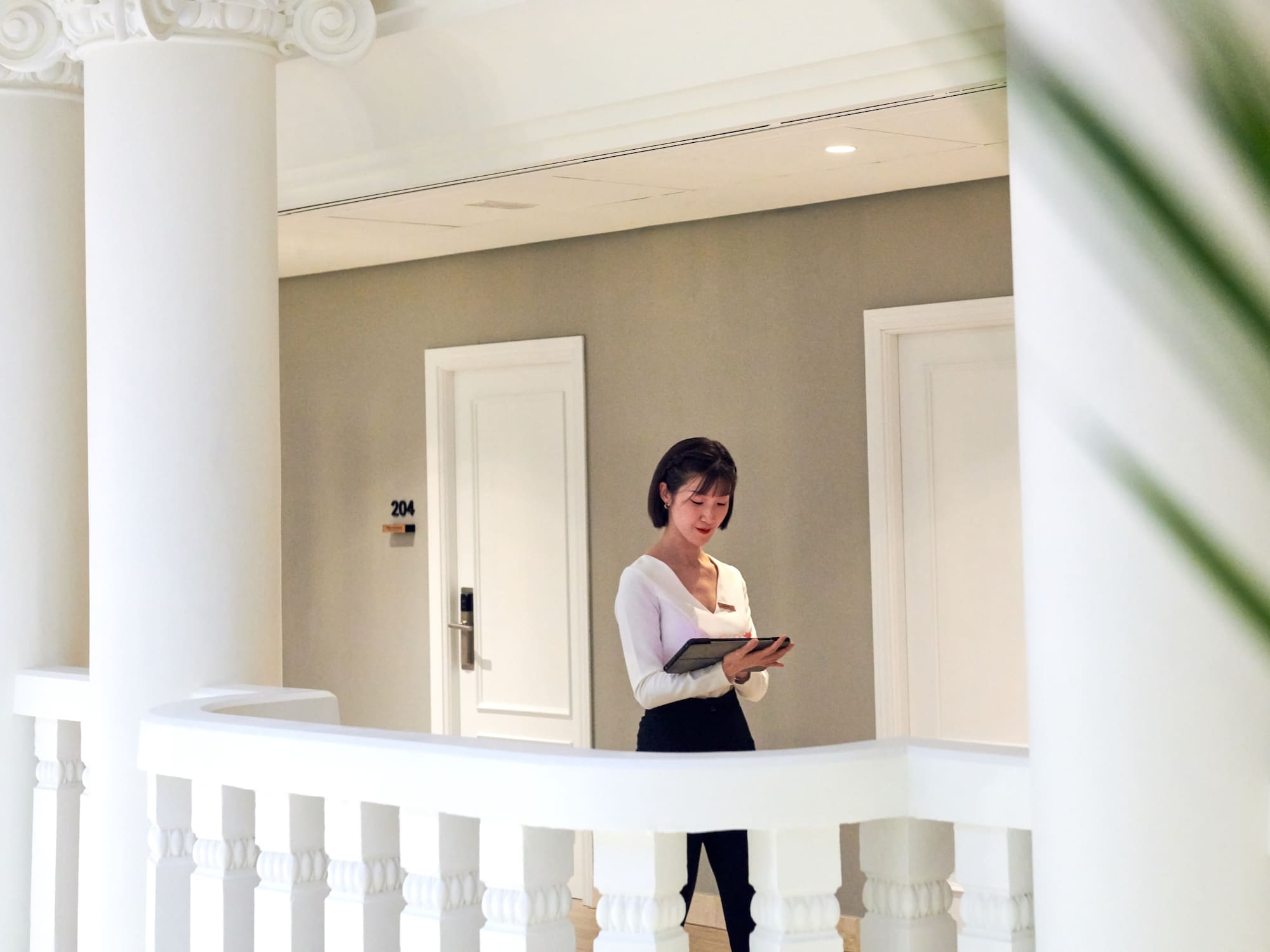 a woman standing in a hallway with a tablet